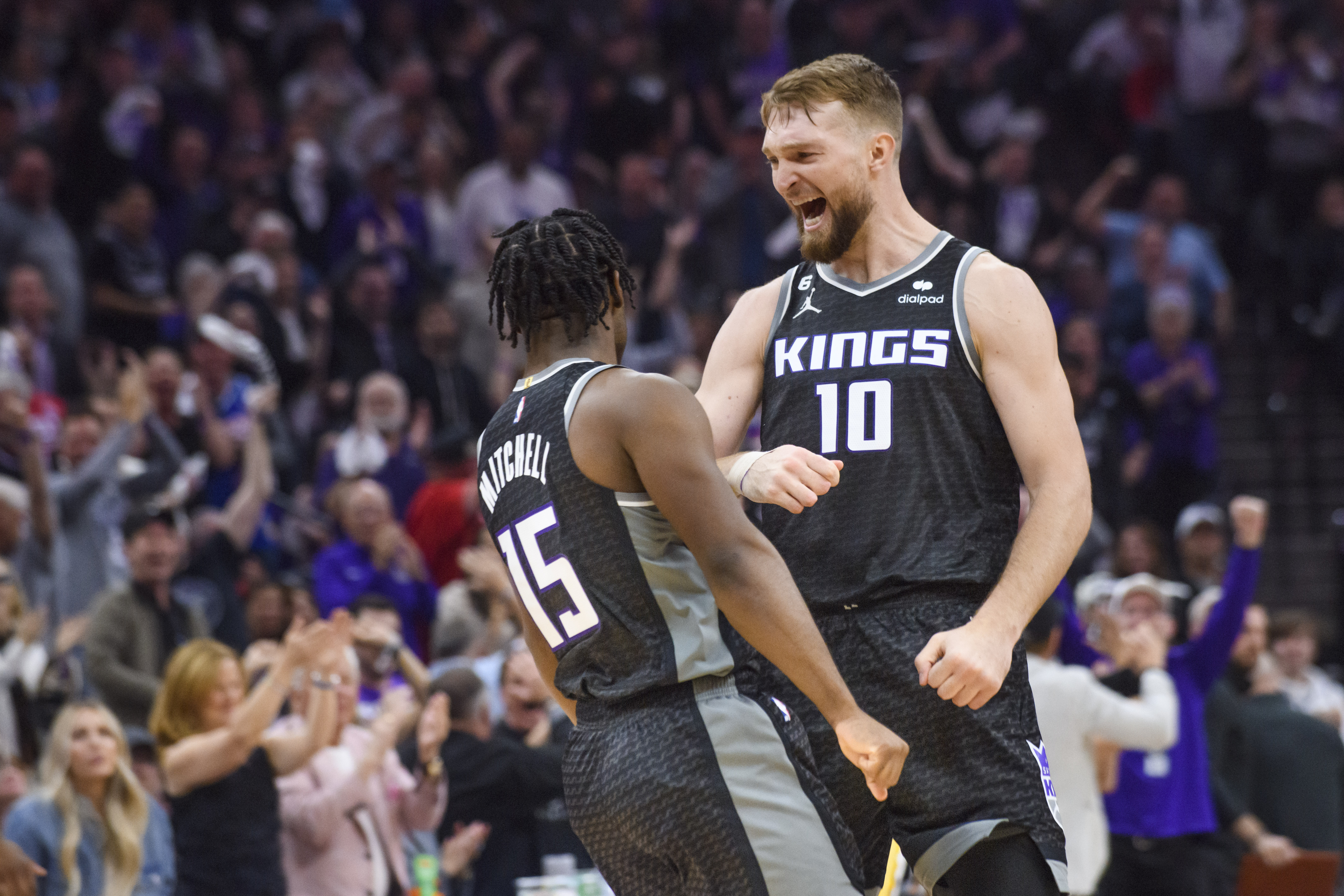 Sacramento Kings forward Domantas Sabonis (10) congratulates guard Davion Mitchell (15) in the first half during Game 1 in the first round of the NBA basketball playoffs against the Golden State Warriors in Sacramento, Calif., Monday, April 17, 2023. (AP Photo/Randall Benton)