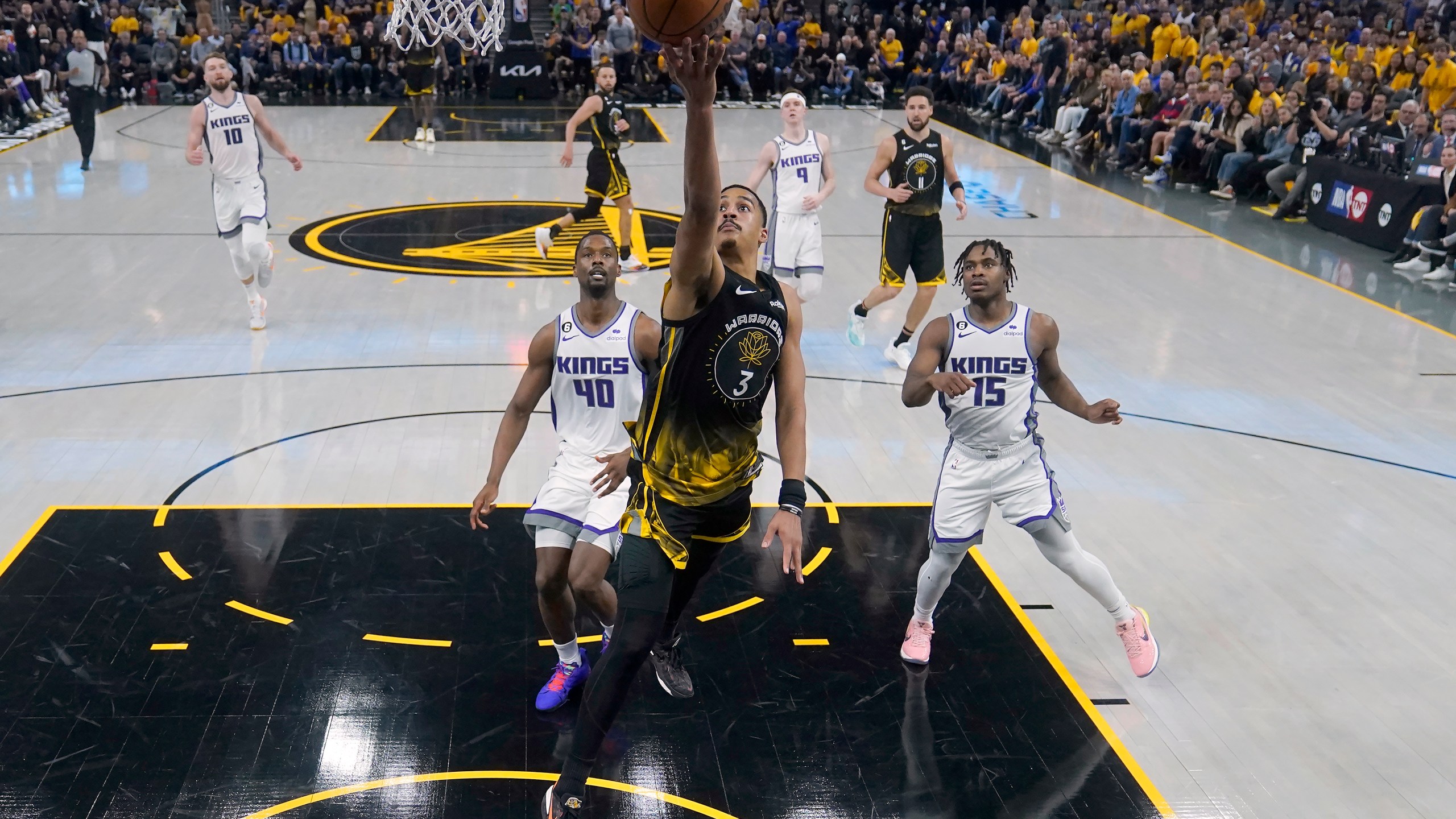 Golden State Warriors guard Jordan Poole (3) shoots against Sacramento Kings forward Harrison Barnes (40) and guard Davion Mitchell (15) during the first half of Game 3 of an NBA basketball first-round playoff seriesin San Francisco, Thursday, April 20, 2023. (AP Photo/Jeff Chiu)