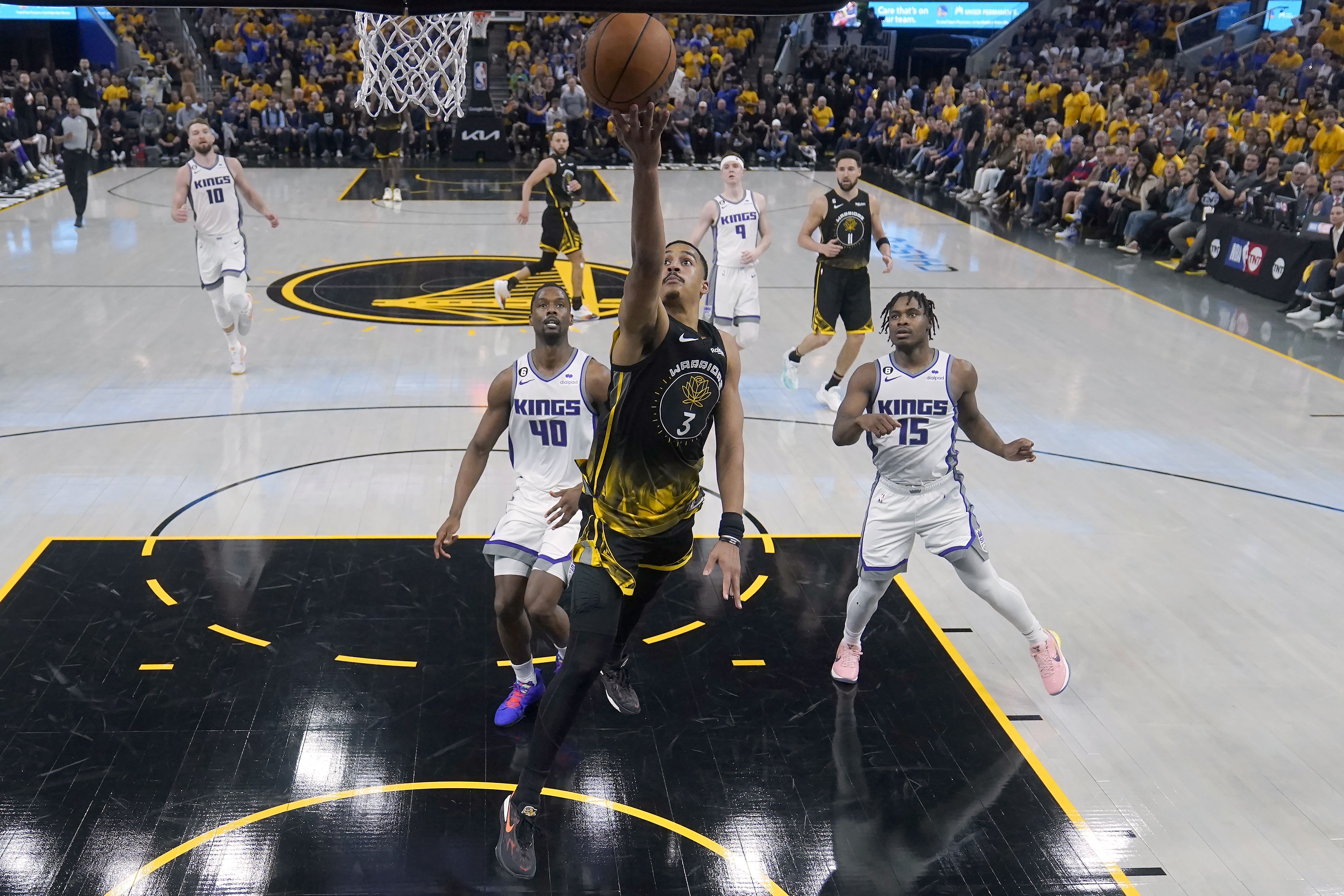 Golden State Warriors guard Jordan Poole (3) shoots against Sacramento Kings forward Harrison Barnes (40) and guard Davion Mitchell (15) during the first half of Game 3 of an NBA basketball first-round playoff seriesin San Francisco, Thursday, April 20, 2023. (AP Photo/Jeff Chiu)