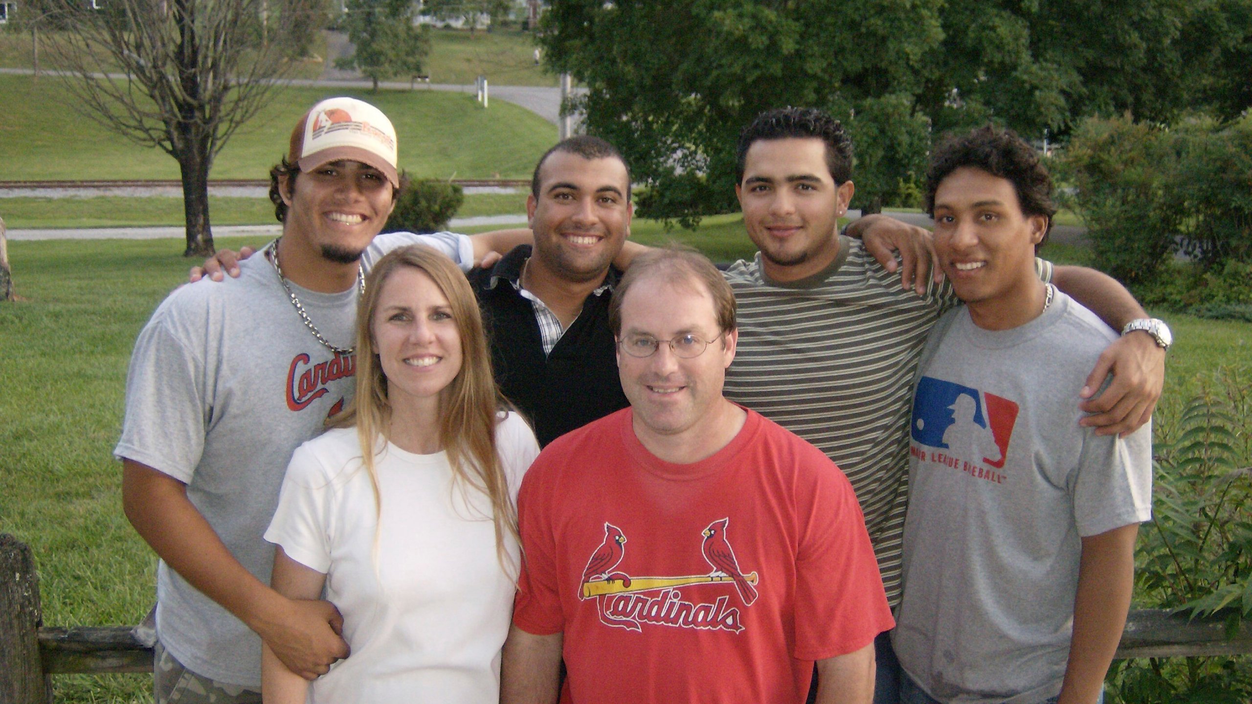 In this photo provided by TeriAnn Reynolds, TeriAnn and John Reynolds, front, pose with, from left, minor league baseball players Reynier González, Andres Rosales, Carlos Elias González and Jorge Rondón outside the Reynolds residence in Johnson City, Tenn., in July 2008. (Photo courtesy TeriAnn Reynolds via AP)