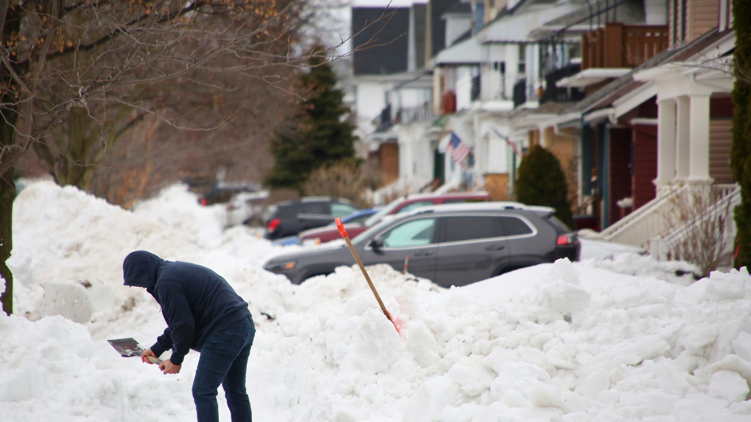 FILE - A person removes snow from the front of his driveway a few days after a winter storm rolled through western New York Thursday, Dec. 29, 2022, in Buffalo, N.Y. A new report finds several shortcomings in Buffalo's response to a historic December blizzard in which 31 city residents died. The report was released Friday, June 2, 2023, by the New York University Wagner School for Public Service. (AP Photo/Jeffrey T. Barnes, File)