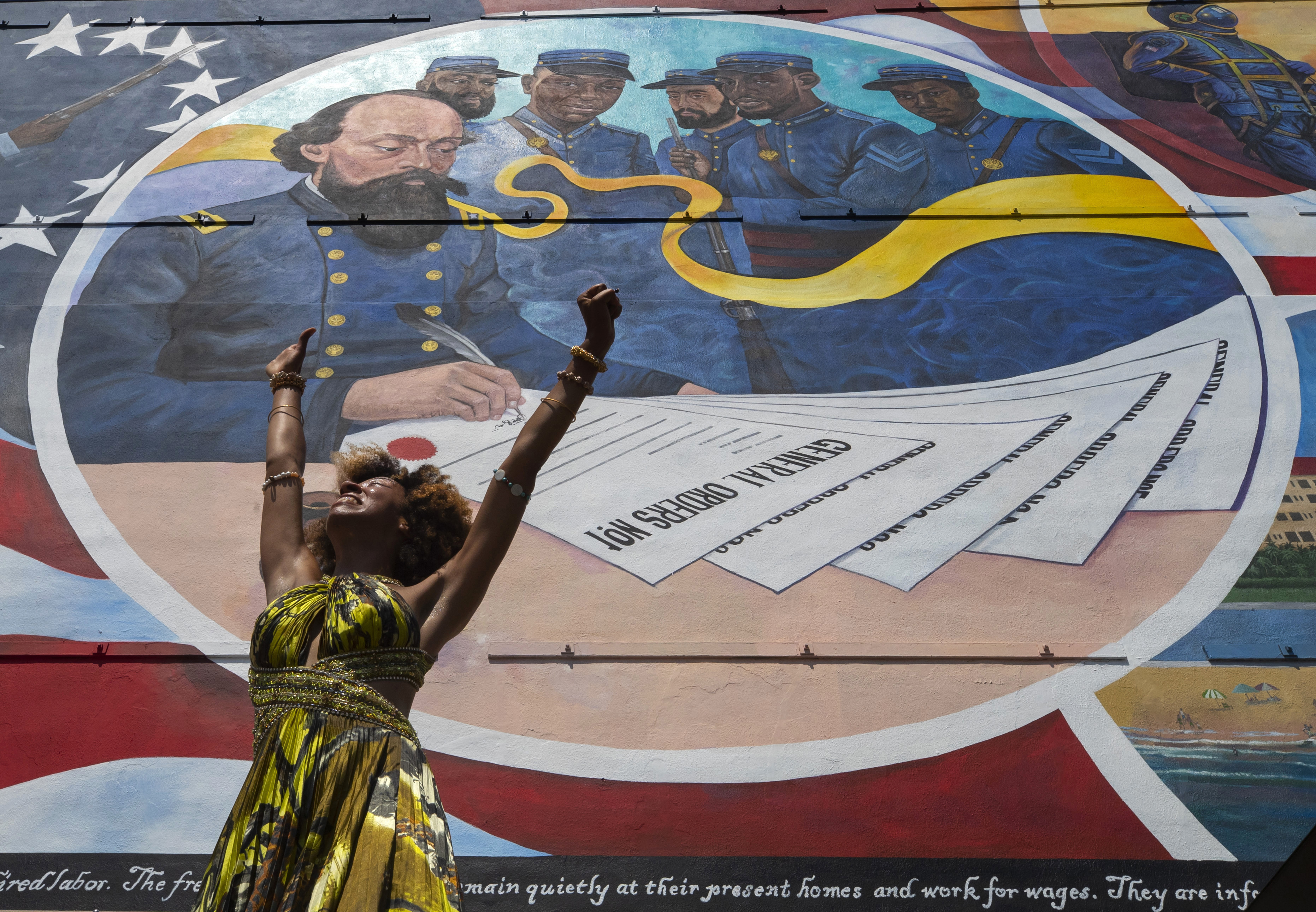 FILE - Dancer Prescylia Mae, of Houston, performs during a dedication ceremony for the massive mural "Absolute Equality" in downtown Galveston, Texas, on June 19, 2021. Communities all over the country will be marking Juneteenth, the day that enslaved Black Americans learned they were free. For generations, the end of one of the darkest chapters in U.S. history has been recognized with joy in the form of parades, street festivals, musical performances or cookouts. Yet, the U.S. government was slow to embrace the occasion. (Stuart Villanueva/The Galveston County Daily News via AP, File)