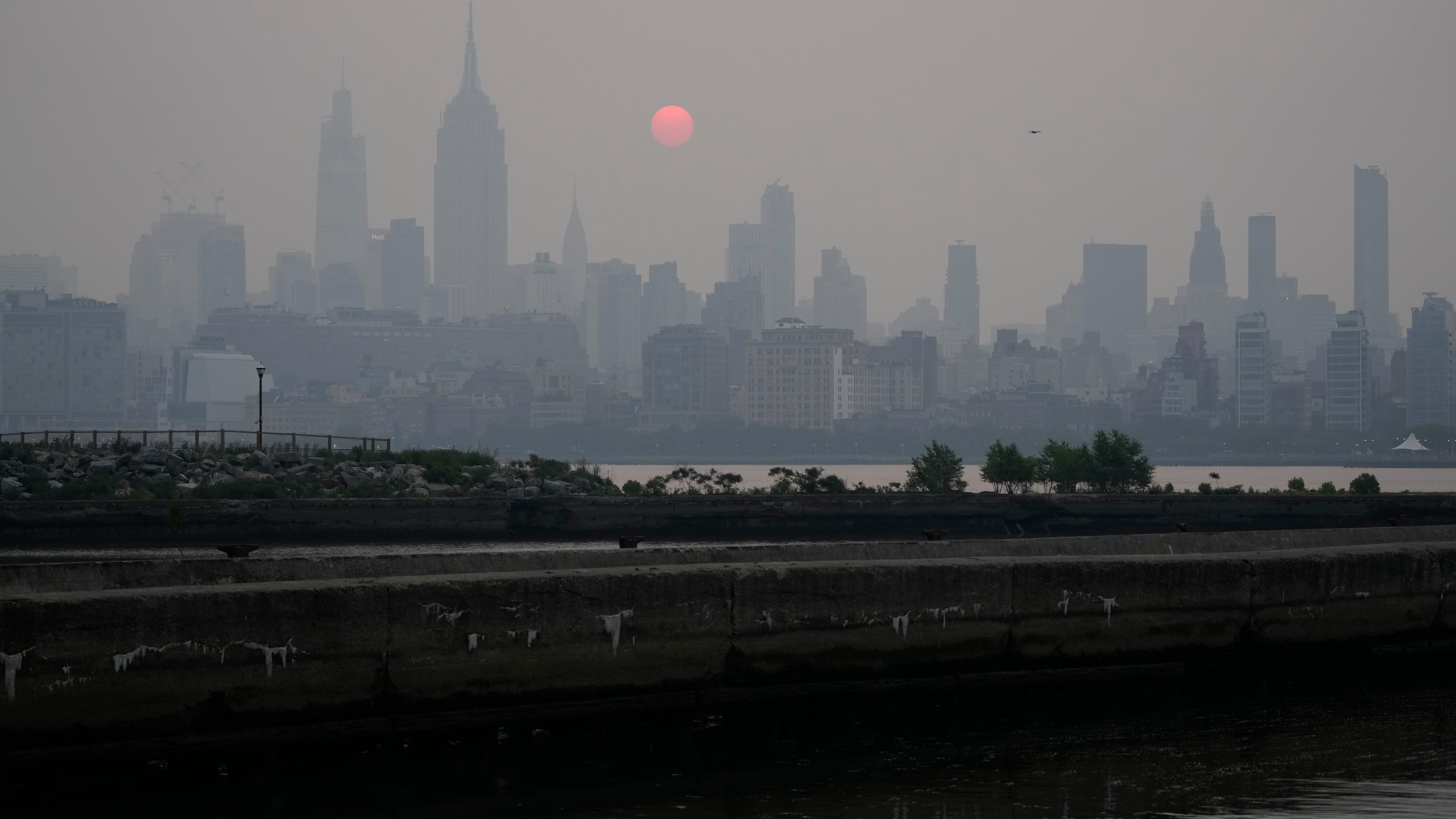 The sun rises over a hazy New York City skyline as seen from Jersey City, N.J., Wednesday, June 7, 2023. Intense Canadian wildfires are blanketing the northeastern U.S. in a dystopian haze, turning the air acrid, the sky yellowish gray and prompting warnings for vulnerable populations to stay inside. (AP Photo/Seth Wenig)