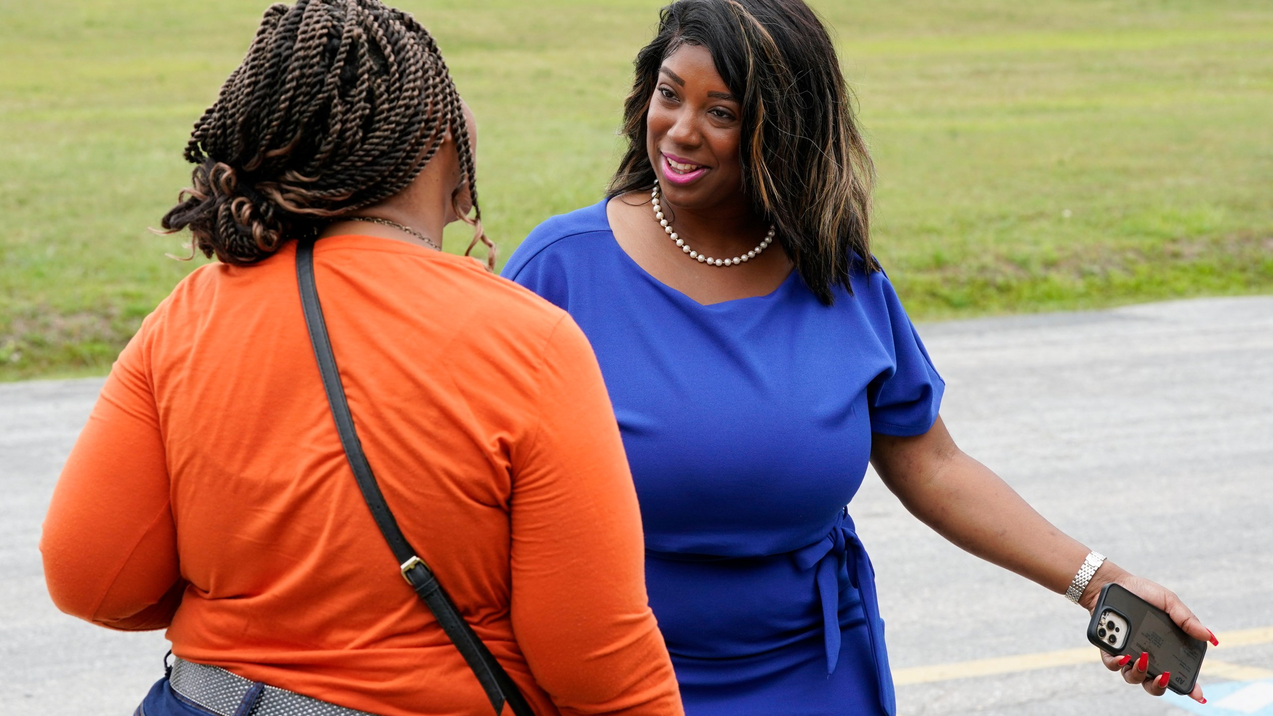 Former Virginia State Delegate Lashrecse Aird, right, talks with a voter as she visits a polling precinct Tuesday, June 20, 2023, in Surry, Va. Aird is running against Virginia State Sen. Joe Morrissey in a Democratic primary for a newly redrawn Senate district. (AP Photo/Steve Helber)