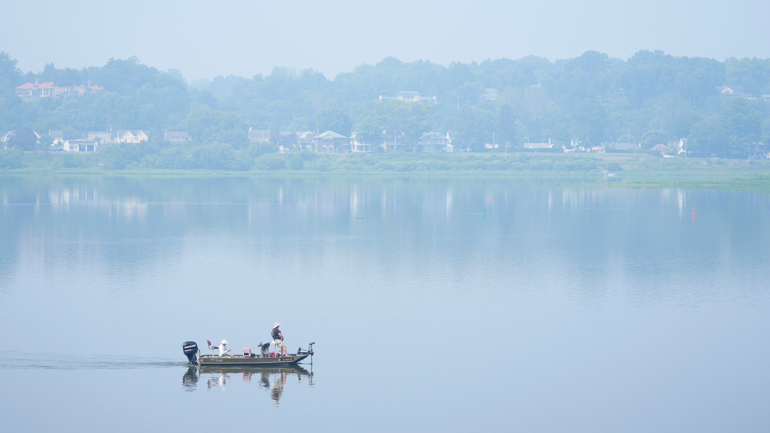 People fish on the Susquehanna River amidst haze from Canadian wildfires, Thursday, June 29, 2023, in Harrisburg, Pa. (AP Photo/Matt Rourke)