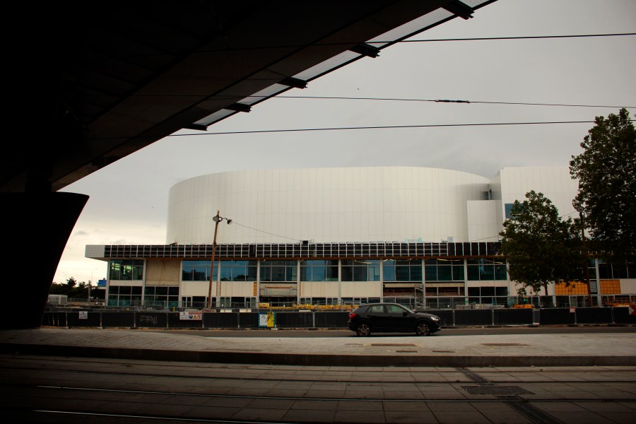 A car drives past the future Olympic venue "Porte de la Chapelle Arena" in Paris, Sunday, July 23, 2023. Paris authorities are trying to clear out crack users from a long-blighted neighborhood near a new venue built for the Paris 2024 Olympics, with mixed effects. (AP Photo/Youcef Bounab)