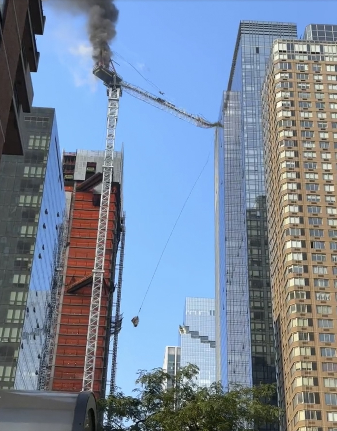 The arm of a tall construction crane crashes into a building and on to the street below after catching on fire in Manhattan on Wednesday, July 26, 2023 in New York. Some people suffered minor injuries, but no one died, according to Mayor Eric Adams. (Jimmy Farrington via AP)