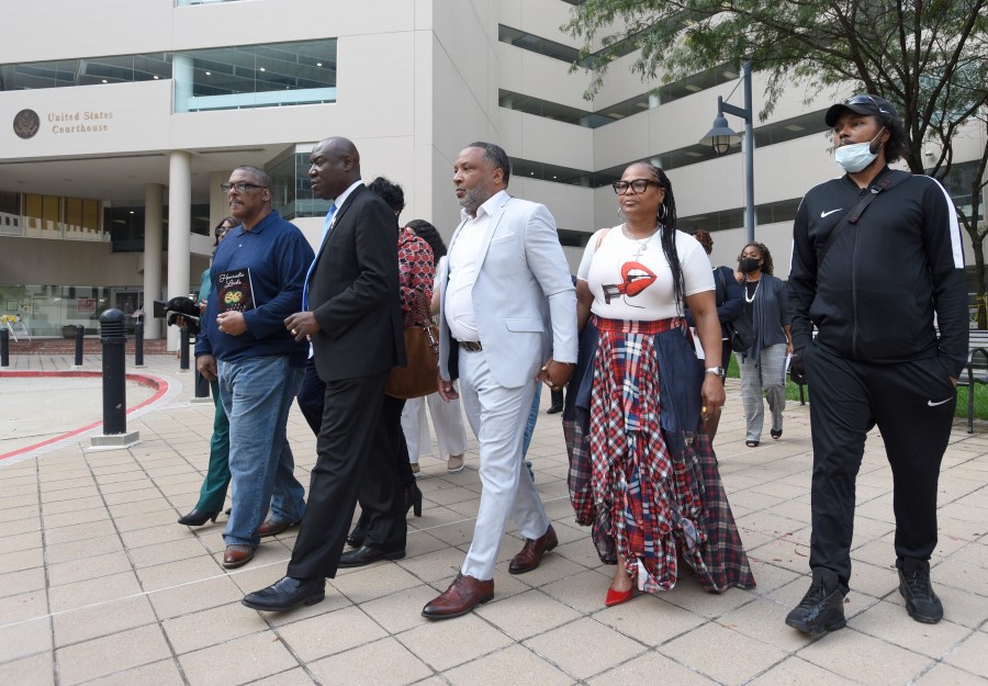 FILE - Attorney Ben Crump, second from left, walks with Ron Lacks, left, Alfred Lacks Carter, third from left, both grandsons of Henrietta Lacks, and other descendants of Lacks, outside the federal courthouse in Baltimore, Oct. 4, 2021. The family of Henrietta Lacks is settling a lawsuit against a biotechnology company it accuses of improperly profiting from her cells. Their federal lawsuit in Baltimore claimed Thermo Fisher Scientific has made billions from tissue taken without the Black woman’s consent from her cervical cancer tumor. (AP Photo/Steve Ruark, file)