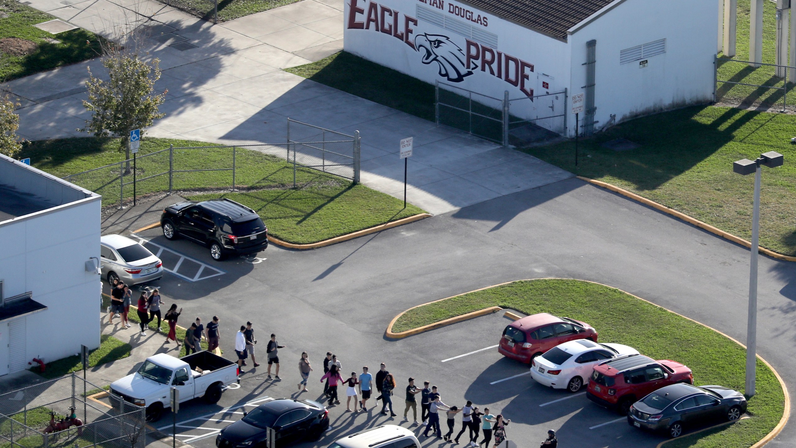 FILE - Students are evacuated by police from Marjory Stoneman Douglas High School, Wednesday, Feb. 14, 2018, in Parkland, Fla., after a shooter opened fire on the campus. A reenactment of the 2018 massacre that left 17 dead, 17 wounded and hundreds emotionally traumatized, is scheduled to be conducted Friday, Aug. 4, 2023, as part of lawsuits filed by the victims' families and the injured. (Mike Stocker/South Florida Sun-Sentinel via AP, File)