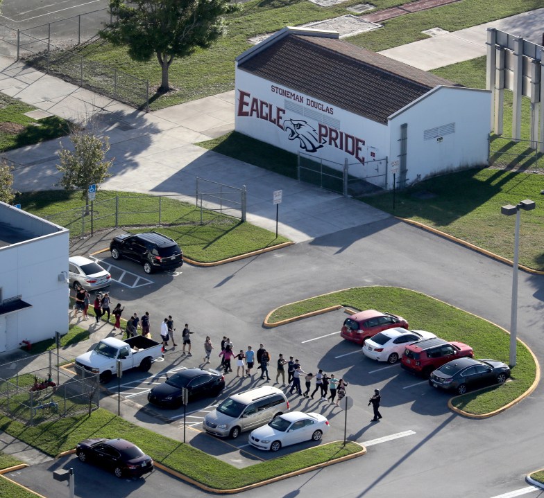 FILE - Students are evacuated by police from Marjory Stoneman Douglas High School, Wednesday, Feb. 14, 2018, in Parkland, Fla., after a shooter opened fire on the campus. A reenactment of the 2018 massacre that left 17 dead, 17 wounded and hundreds emotionally traumatized, is scheduled to be conducted Friday, Aug. 4, 2023, as part of lawsuits filed by the victims' families and the injured. (Mike Stocker/South Florida Sun-Sentinel via AP, File)