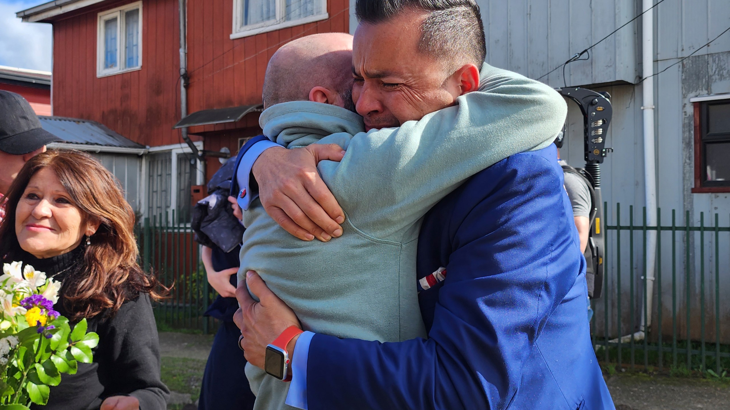 In this image provided by Constanza Del Rio/Nos Buscamos, Jimmy Thyden, right, hugs his brother Pablo Leiva Gonzalez as Maria Angelica Gonzalez, his Chilean birth mother, left, looks on in Valdivia, Chile on Aug. 17, 2023. Thyden got to embrace his birth mother for the first time during the long-awaited family reunion in Valdivia. For months Thyden has been on a journey to uncover the mysteries of his counterfeit adoption, and to reconnect with his biological mother, brothers and sister. (Constanza Del Rio/Nos Buscamos via AP)