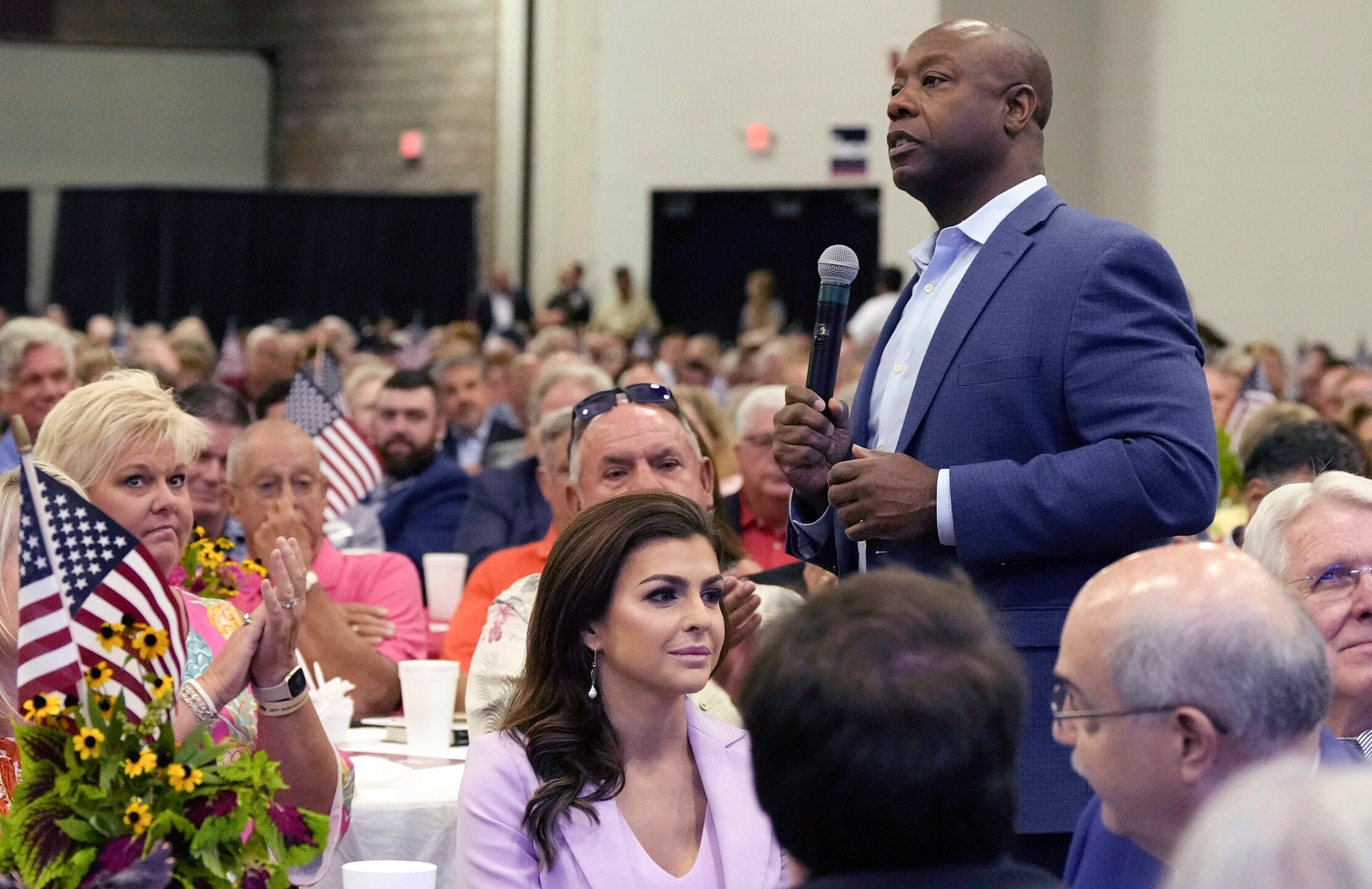 FILE - Republican presidential candidate Sen. Tim Scott, R-S.C., right, walks by Casey DeSantis, wife of GOP rival and Florida Gov. Ron DeSantis, center, as he speaks at Rep. Jeff Duncan's Faith & Freedom BBQ fundraiser, Aug. 28, 2023, in Anderson, S.C. Republicans are responding to a late summer spike in COVID-19 by raising familiar fears that government-issued lockdowns and mask mandates are on the horizon. GOP presidential hopefuls including Florida Gov. Ron DeSantis, South Carolina Sen. Tim Scott and former President Donald Trump have spread this narrative in the last week. (AP Photo/Meg Kinnard, File)