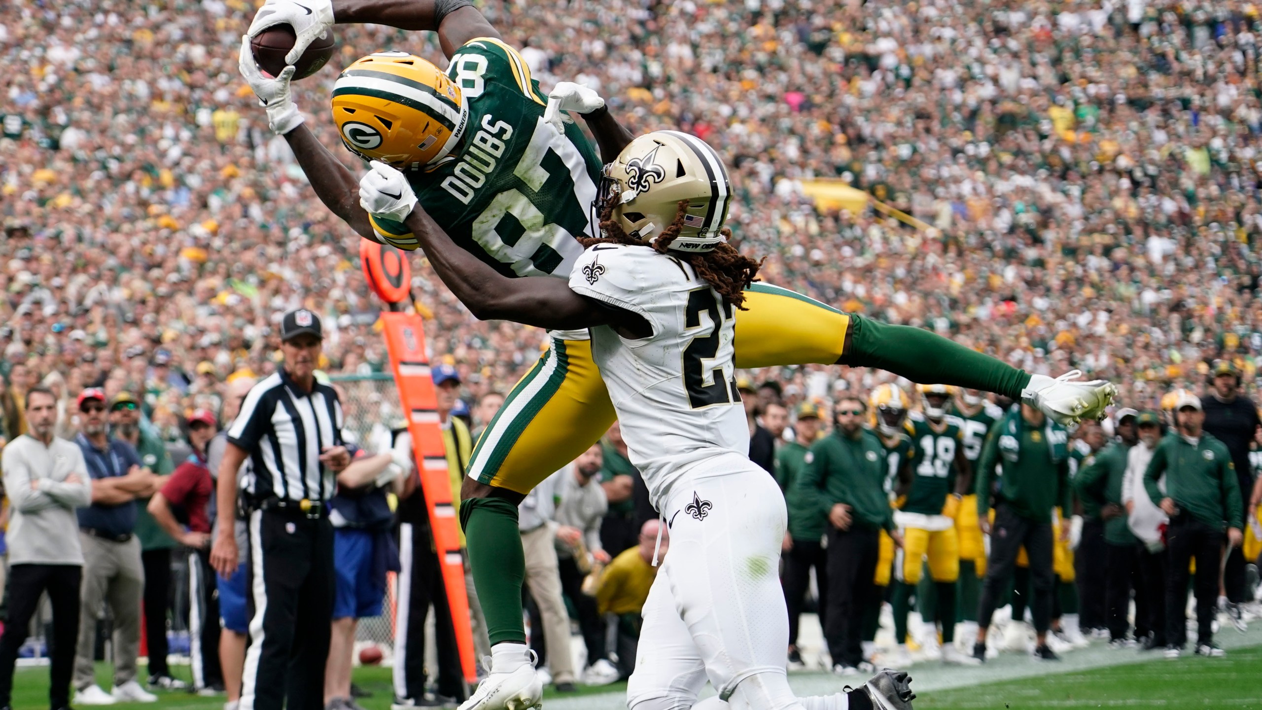 Green Bay Packers wide receiver Romeo Doubs (87) pulls in a touchdown reception against New Orleans Saints cornerback Isaac Yiadom during the second half of an NFL football game Sunday, Sept. 24, 2023, in Green Bay, Wis. (AP Photo/Morry Gash)