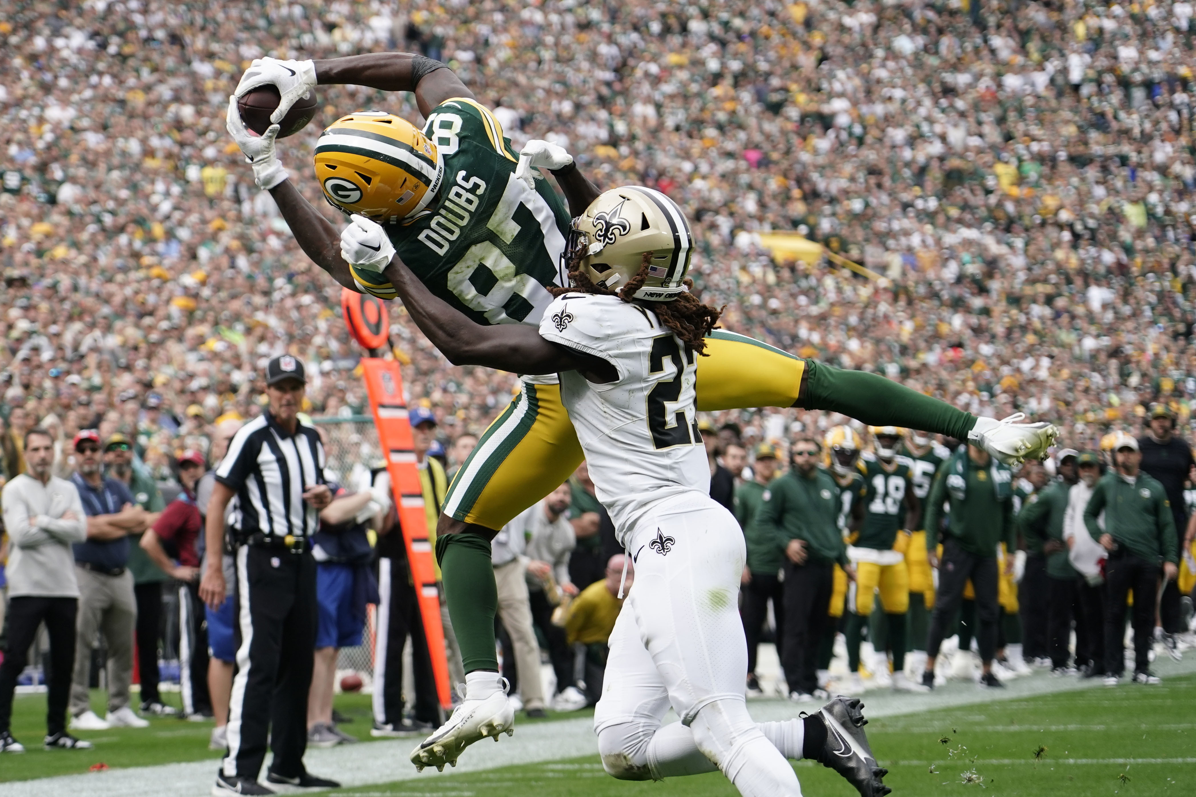 Green Bay Packers wide receiver Romeo Doubs (87) pulls in a touchdown reception against New Orleans Saints cornerback Isaac Yiadom during the second half of an NFL football game Sunday, Sept. 24, 2023, in Green Bay, Wis. (AP Photo/Morry Gash)