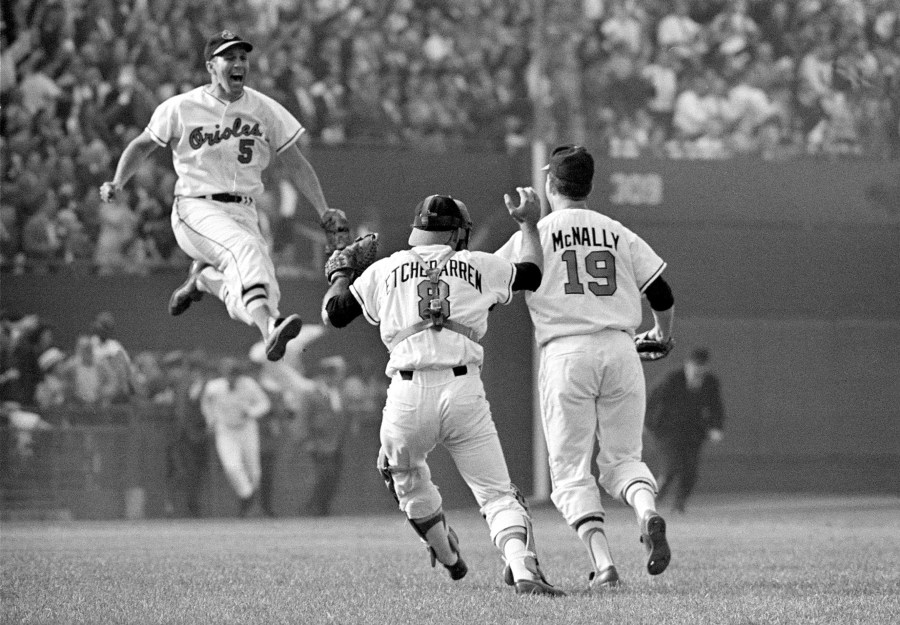 FILE - Baltimore Orioles third baseman Brooks Robinson (5) leaps across the infield to congratulate pitcher Dave McNally (19) and Orioles catcher Andy Etchebarren (8) after the final out in a World Series baseball game against the Los Angeles Dodgers in Baltimore, Md., on Oct. 9, 1966. Robinson, whose deft glovework and folksy manner made him one of the most beloved and accomplished athletes in Baltimore history, has died, according to a joint announcement by the Orioles and his family Tuesday, Sept. 26, 2023. (AP Photo/Bob Daugherty, File)