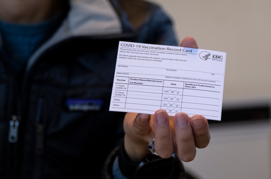 FILE - A nurse practitioner holds a COVID-19 vaccine card at a New York Health and Hospitals vaccine clinic in the Brooklyn borough of New York on Jan. 10, 2021. Now that COVID-19 vaccines are being distributed through the commercial markets instead of by the federal government in 2023, the Centers for Disease Control and Prevention won't be shipping out any more new cards. (AP Photo/Craig Ruttle, File)