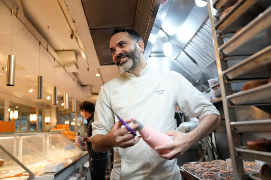 Dominique Ansel helps to prepare for opening at his namesake bakery in New York, Thursday, Sept. 28, 2023. In 2013, before most people knew the term “going viral,” the French pastry chef created the Cronut, a cross between a croissant and a doughnut, at his newly opened New York bakery. (AP Photo/Seth Wenig)