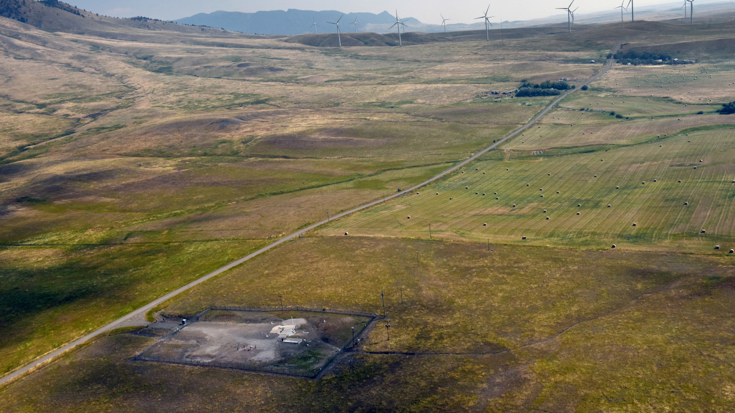 In this image provided by the U.S. Air Force, wind turbines spin near the Malmstrom Air Force Base missile launch site Alpha-03 in Geyser, Mont., in August 2023. As the nation's energy needs have increased, turbines have grown in size and number, and are being placed closer to the underground silos where Minuteman III intercontinental ballistic missiles are kept ready to fire. The Air Force is concerned that the turbines are making it dangerous for their helicopter crews to fly out to the sites, often flying low and fast, when responding to an alarm at one of the silos. The service is seeking a two nautical mile buffer zone around the sites. (John Turner/U.S. Air Force via AP)