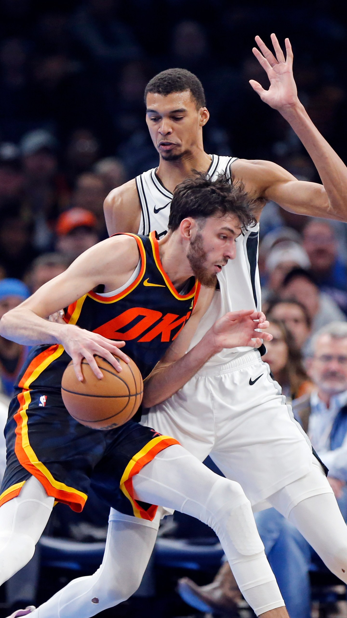 Oklahoma City forward Chet Holmgren, left, dribbles as San Antonio center Victor Wembanyama defends during the first half of an NBA in-season tournament basketball game Tuesday, Nov. 14, 2023, in Oklahoma City. (AP Photo/Nate Billings)