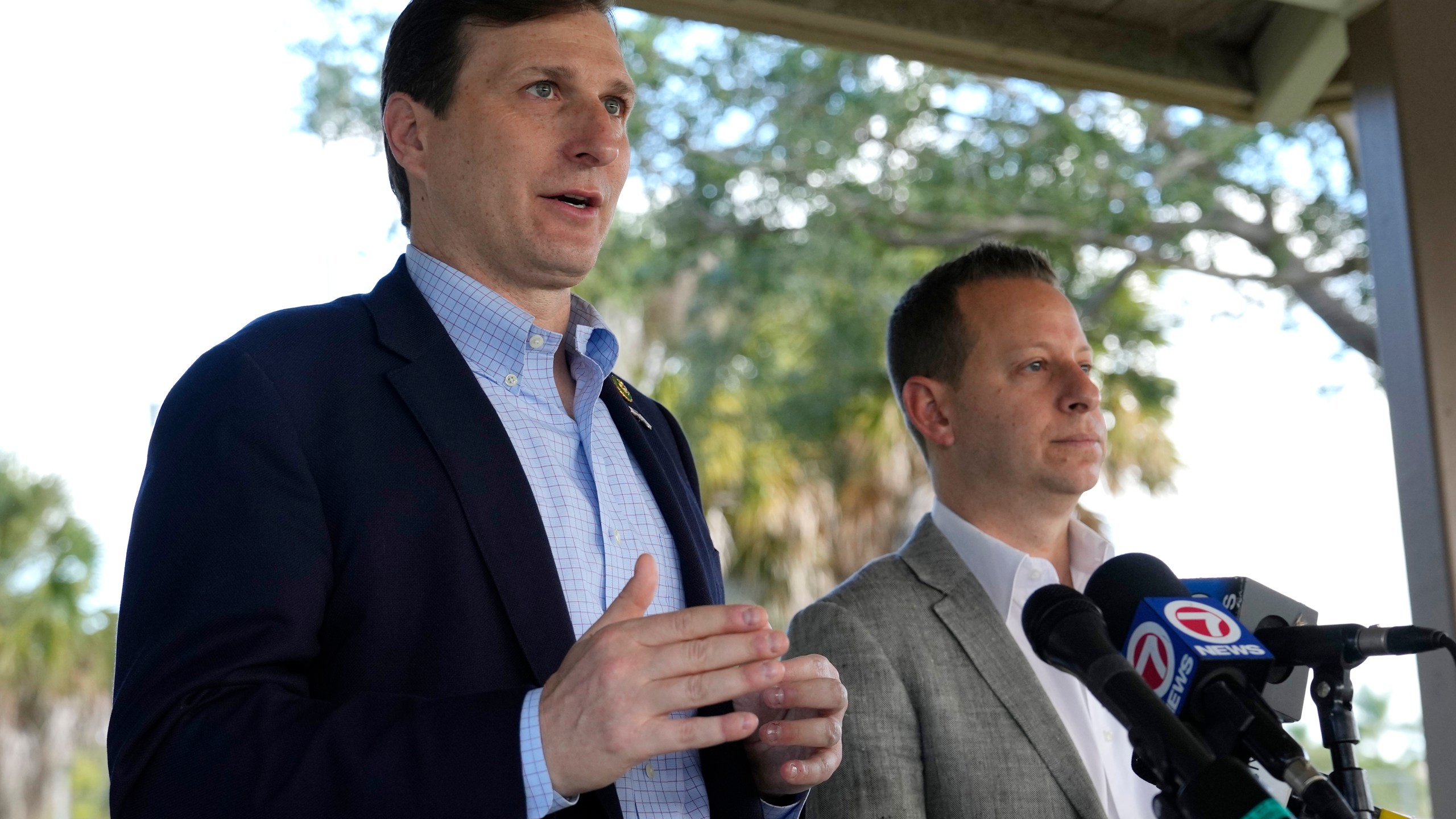 U.S. Rep. Daniel Goldman, D-N.Y., left, speaks with the news media before a tour of Marjory Stoneman Douglas High School, Monday, Nov. 20, 2023, in Parkland, Fla. Fourteen students and three staff members were fatally shot at the school in 2018. At right is Rep. Jared Moskowitz, D-Fla., right. (AP Photo/Lynne Sladky)