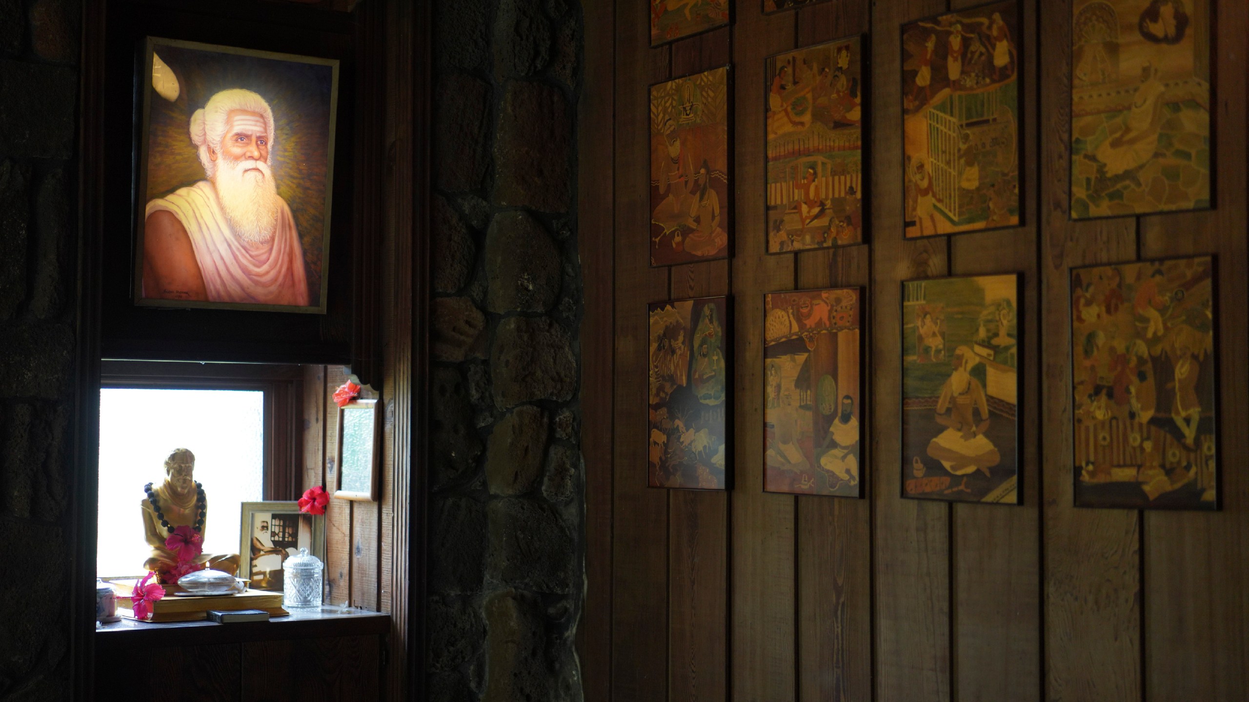 A lit photo of Satguru Sivaya Subramuniyaswami, left, the founding guru of Kauai's Hindu Monastery, hangs in a meditation room on July 13, 2023, in Kapaa, Hawaii. The temple monastery was founded in 1970. (AP Photo/Jessie Wardarski)