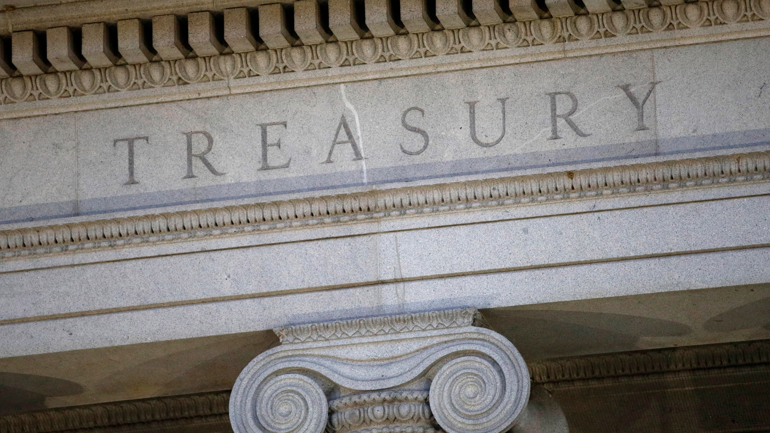 FILE- The U.S. Treasury Department building is shown at dusk in Washington on June 6, 2019. The U.S. has imposed new sanctions on alleged violators of the price cap on Russian oil and tightened compliance rules for insurance firms and shippers that move Russian oil. Firms from the United Arab Emirates and Hong Kong have been identified for economic sanctions. (AP Photo/Patrick Semansky, File)