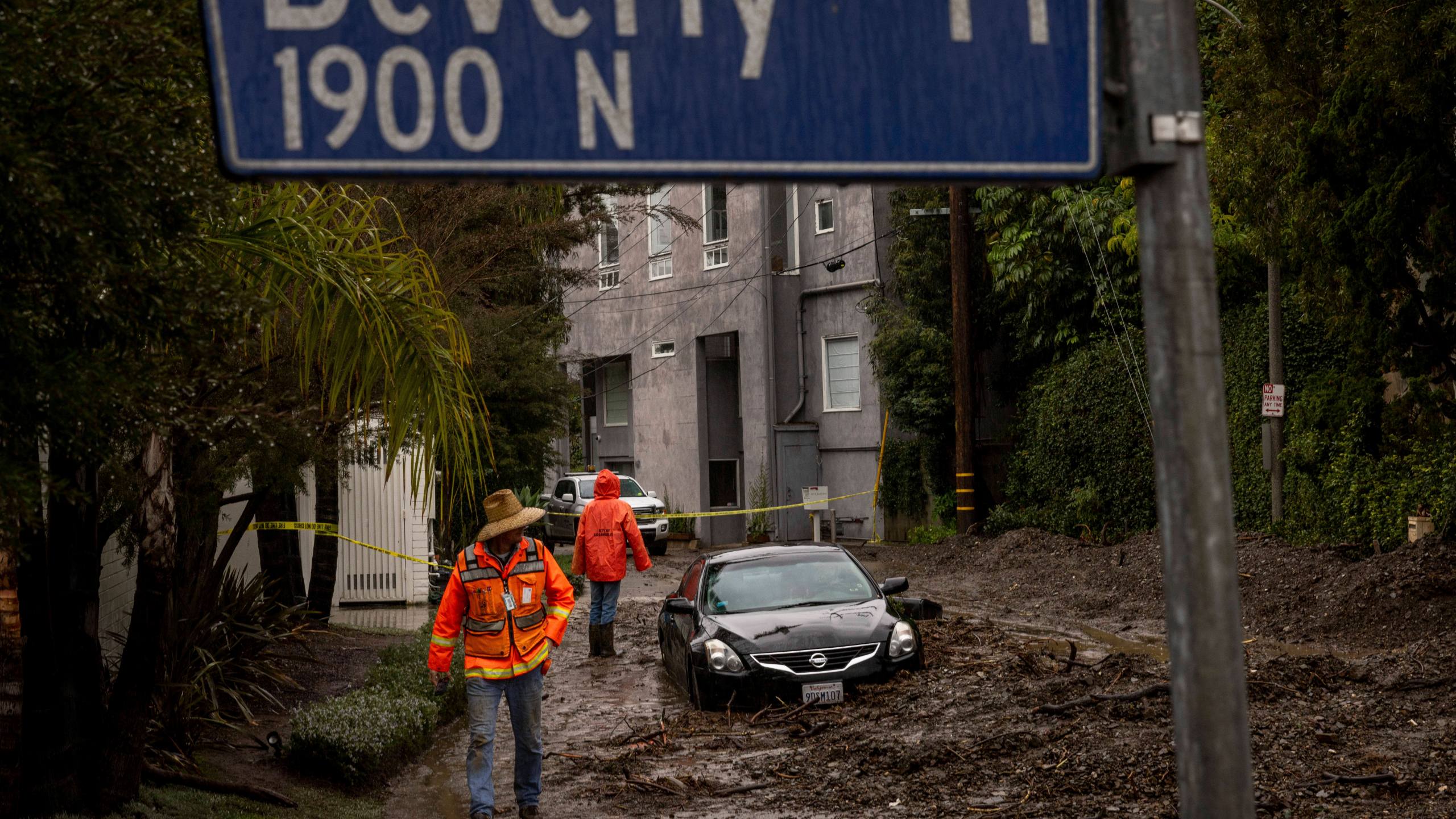 Workers survey a mudslide Tuesday, Feb. 6, 2024, in the Beverly Crest area of Los Angeles. (AP Photo/Ethan Swope)