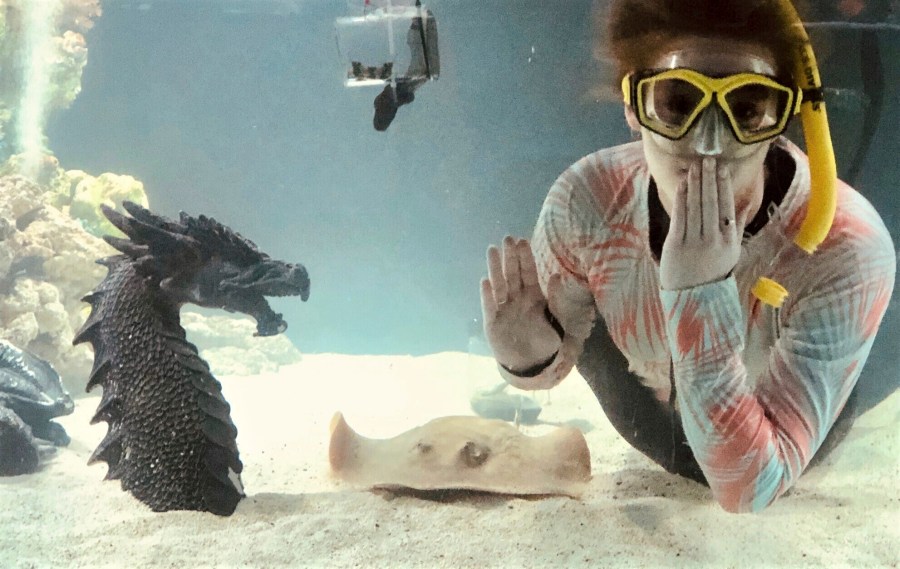 Kinsley Boyette, assistant director of the Aquarium and Shark Lab by Team ECCO, poses in this undated photo next to Charlotte, a round stingray, in Hendersonville, N.C. The aquarium said Tuesday, Feb. 13, 2024, that Charlotte is pregnant, even though she's lived at the aquarium for years without a male companion of her species. (Aquarium and Shark Lab by Team ECCO via AP)