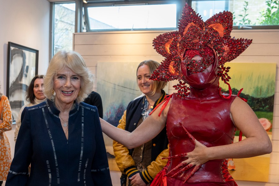 FILE - Britain's Queen Camilla, left, meets costume designer Syban Velardi-Laufer during her visit to Kindred Studios' Shepherds Bush pop-up hub, an art studios and creative space encouraging arts, crafts and community cohesion, in London, Wednesday, Feb. 14, 2024. Queen Camilla, once seen as the scourge of the House of Windsor, the woman at the heart of King Charles III’s doomed marriage to the late Princess Diana, has emerged as one of the monarchy’s most prominent emissaries. (Arthur Edwards/Pool Photo via AP, File)