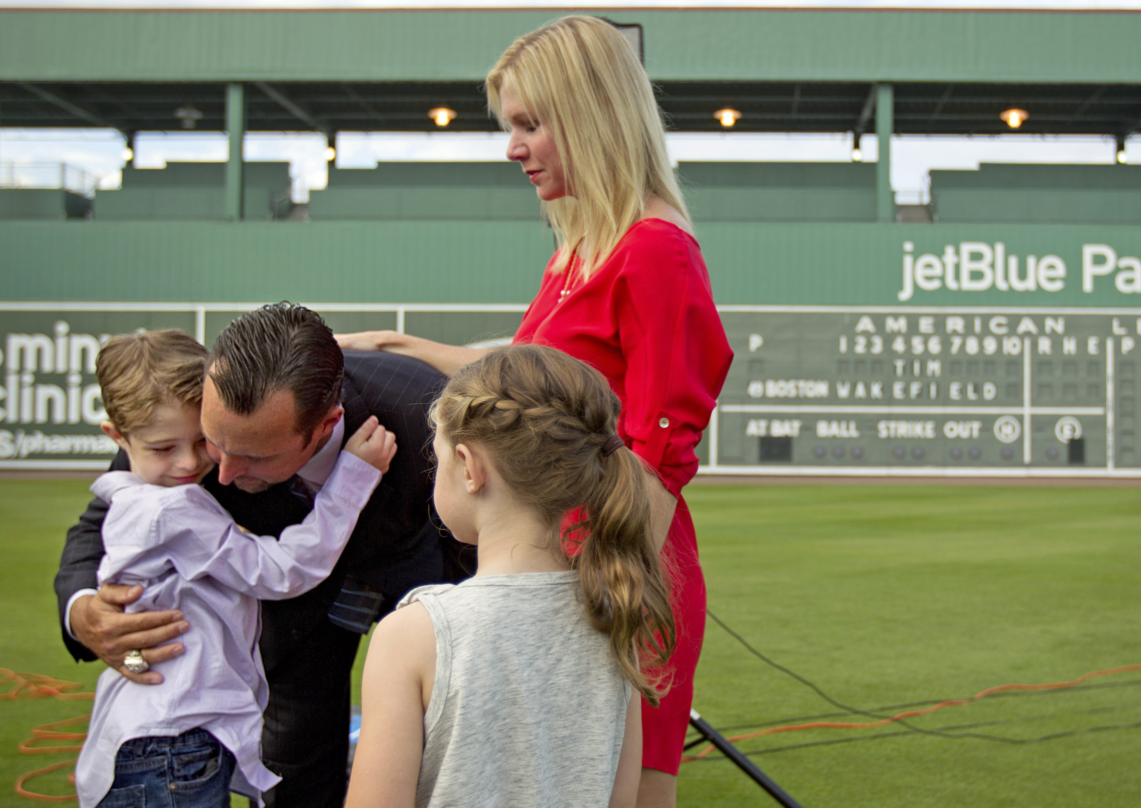 FILE - Boston Red Sox pitcher Tim Wakefield, center left, hugs his son, Trevor, 7, as his wife, Stacy, right, and daughter, Brianna, 6, look on after Wakefield announced his retirement from baseball during a news conference, Friday, Feb. 17, 2012, in Fort Myers, Fla. Stacy Wakefield, the widow of former Boston Red Sox pitcher and two-time World Series champion Tim Wakefield, has died. Wakefield's family said in a statement released through the Red Sox that she died Wednesday, Feb. 28, 2024 at her Massachusetts home, less than five months after her husband died at the age of 57. (AP Photo/David Goldman, File)