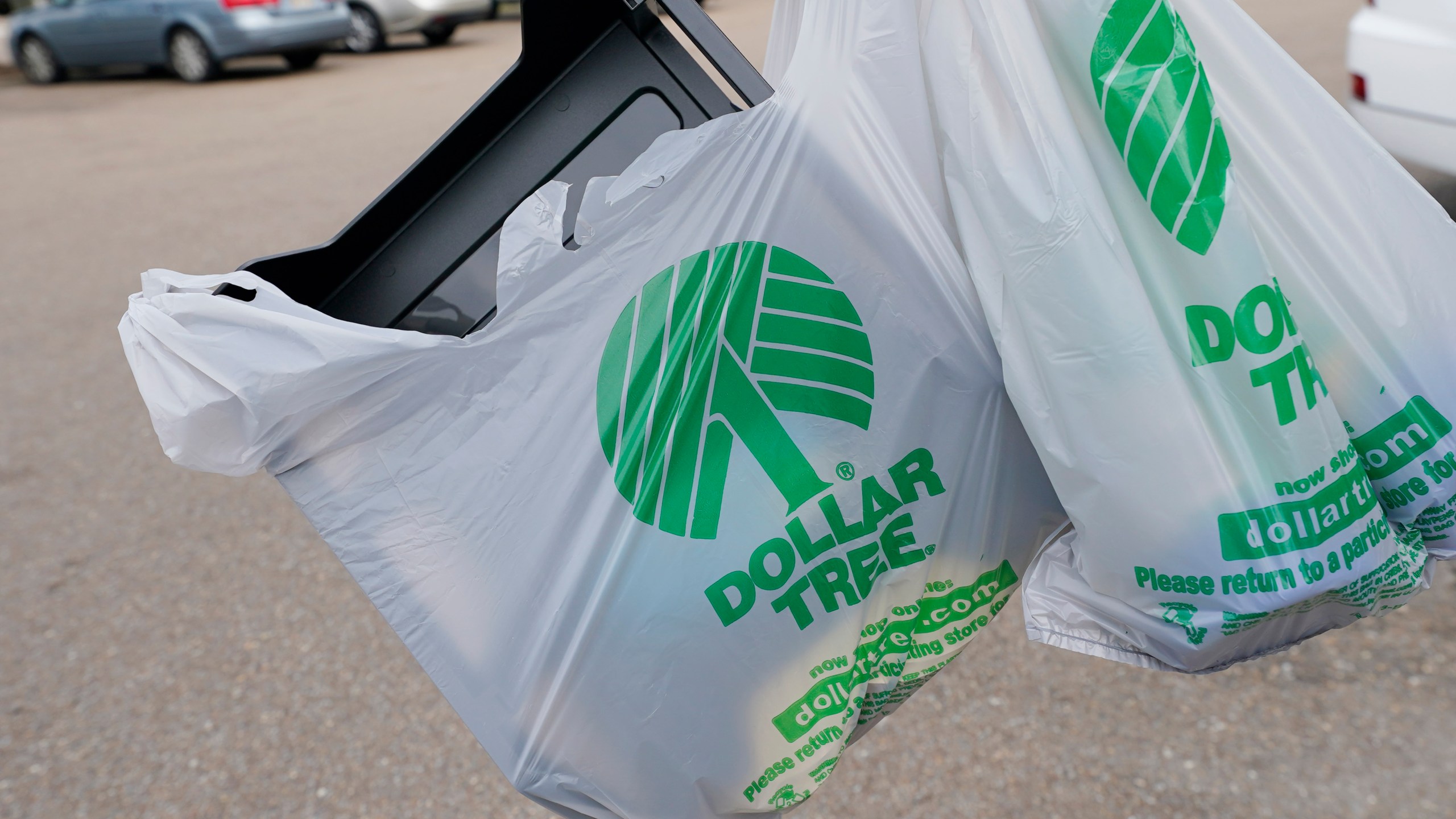 FILE - A customer exits a Dollar Tree store holding a shopping bag on Wednesday, May 11, 2022, in Jackson, Miss. Dollar Tree says it plans to close nearly 1,000 stores and moved to a surprise loss in its fiscal fourth quarter as the discount retailer took a $1.07 billion goodwill impairment charge. Shares dropped more than 7% before the market open on Wednesday, March 13, 2024. (AP Photo/Rogelio V. Solis, File)