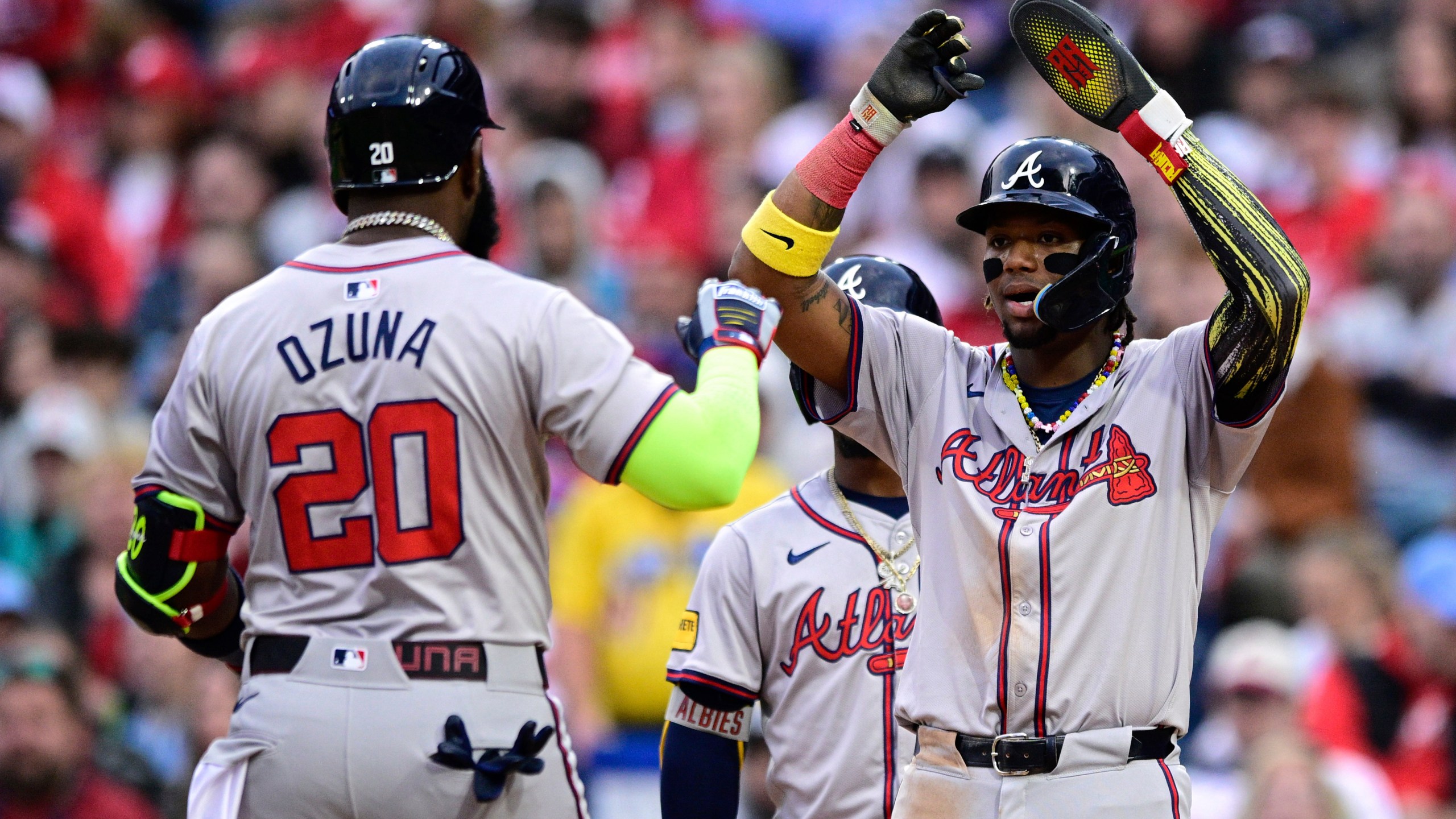 Atlanta Braves' Ronald Acuna Jr., right, high fives Marcell Ozuna (20) after Ozuna hit a three-run home run during the sixth inning of a baseball game against the Philadelphia Phillies, Saturday, March 30, 2024, in Philadelphia. (AP Photo/Derik Hamilton)