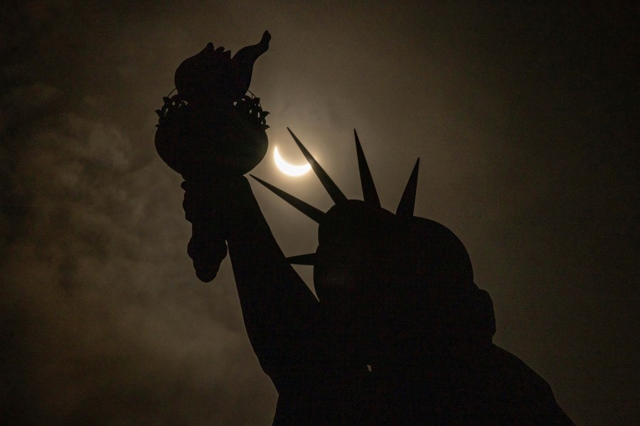 The moon partially covers the sun behind the Statue of Liberty during the a solar eclipse on the Liberty Island, Monday, April. 8, 2024, in New York. (AP Photo/Yuki Iwamura)