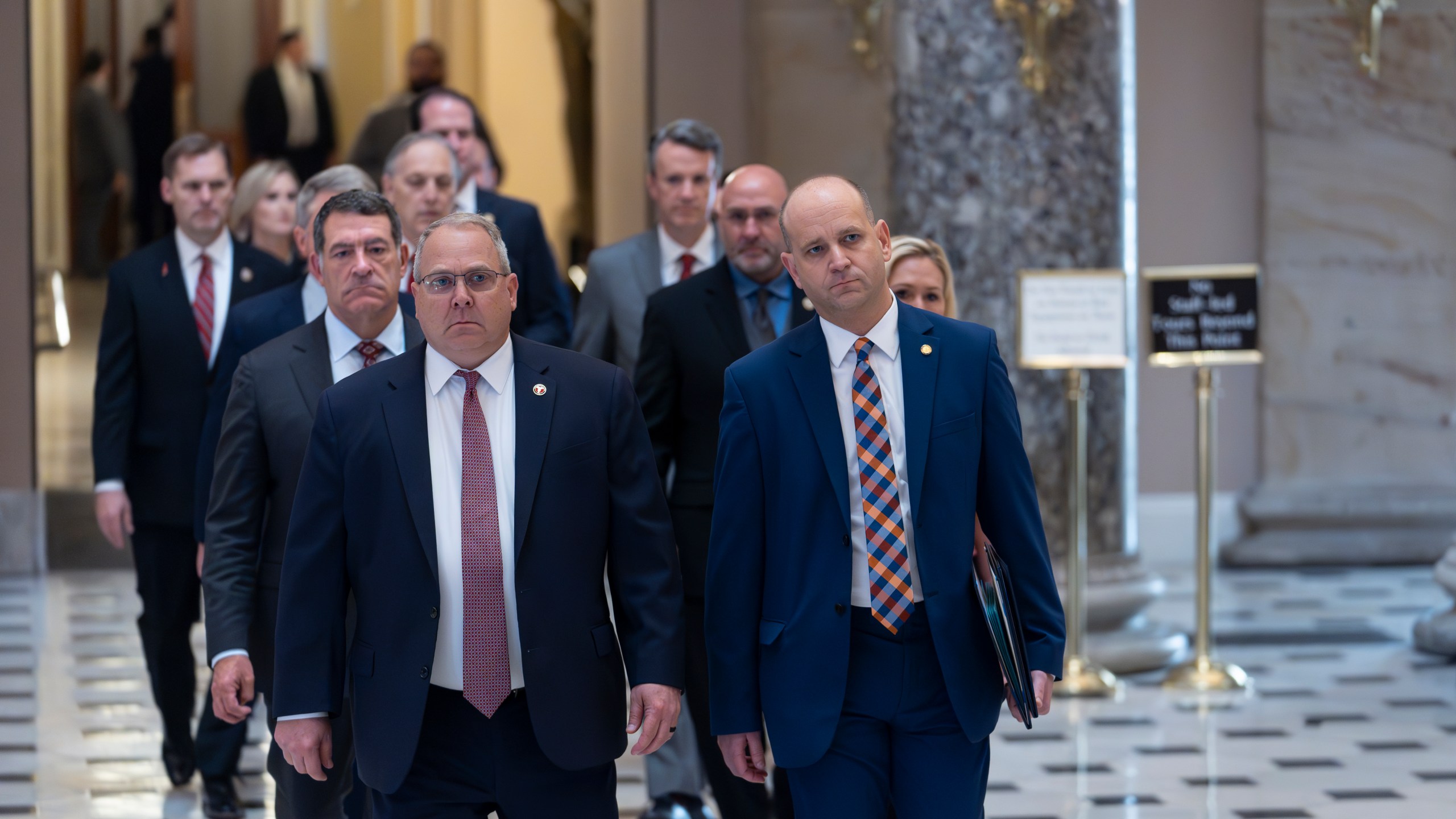 House Republicans, escorted by House Sergeant-at-Arms William McFarland, left, and Acting-Clerk of the House Kevin McCumber, right, walk to the Senate as they deliver the articles of impeachment against Homeland Security Secretary Alejandro Mayorkas, at the Capitol in Washington, Tuesday, April 16, 2024. (AP Photo/J. Scott Applewhite)