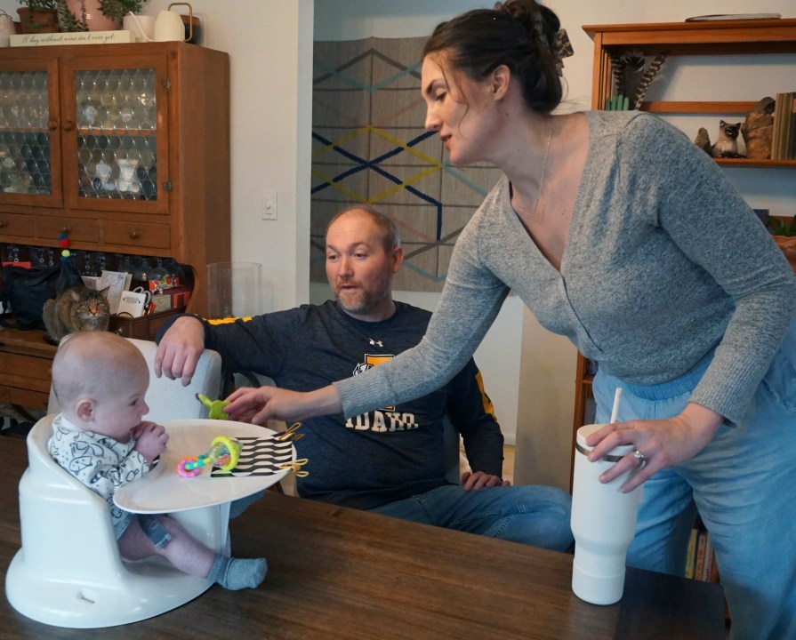 Mike and Jane Roberts tend to their son, Dennis, at their Pocatello, Idaho, home on Friday, March 1, 2024. When Jane Roberts gave birth in November, she and her husband, both teachers, quickly realized sending baby Dennis to day care was out of the question. It was too costly, and they worried about finding a quality provider in their hometown of Pocatello, Idaho.(Carly Flandro/Idaho Education News via AP)