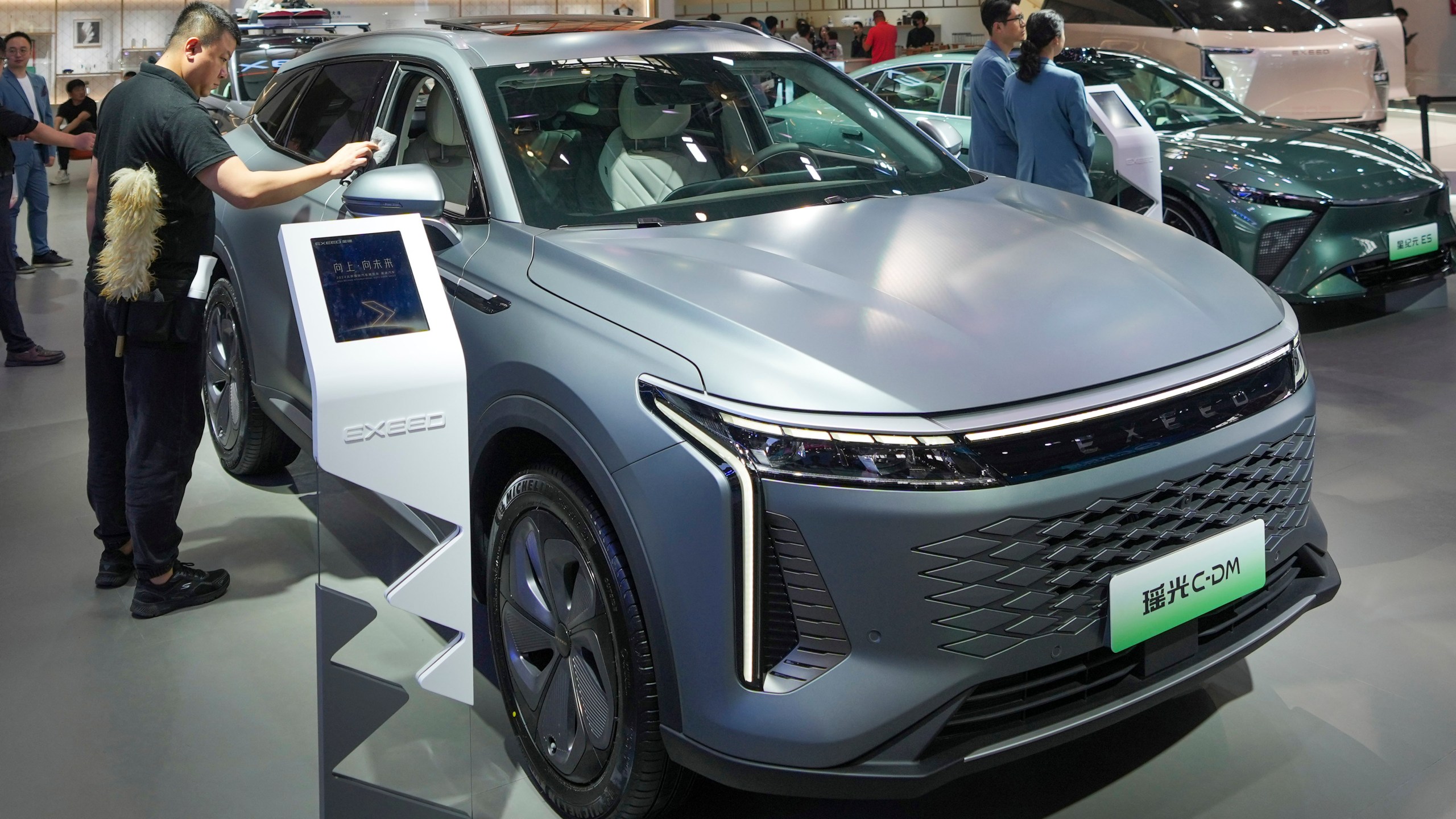 A worker cleans an Exeed C-DM car during the China Auto Show in Beijing, China, Friday, April 26, 2024. China's vision of the future of the automobile — electrified and digitally connected — is on display at the ongoing Beijing auto show. (AP Photo/Tatan Syuflana)