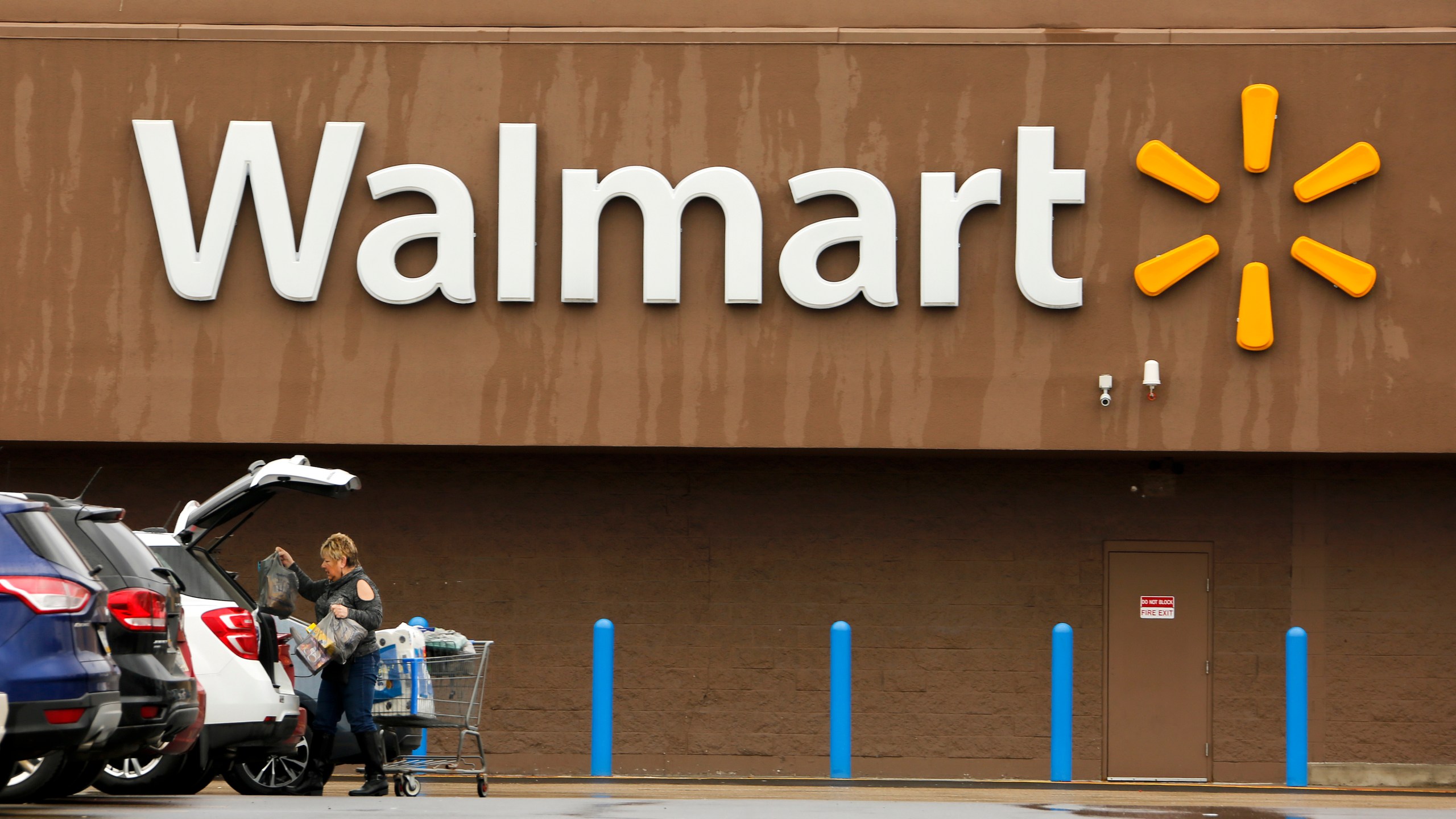 FILE - A shopper loads her car after shopping at a Walmart in Pittsburgh, Thursday, Feb. 22, 2018. Walmart announced Tuesday, April 30, 2024, is closing its health centers and virtual care service, as the retail giant has struggled to find success with the offerings. AP Photo/Gene J. Puskar, File)