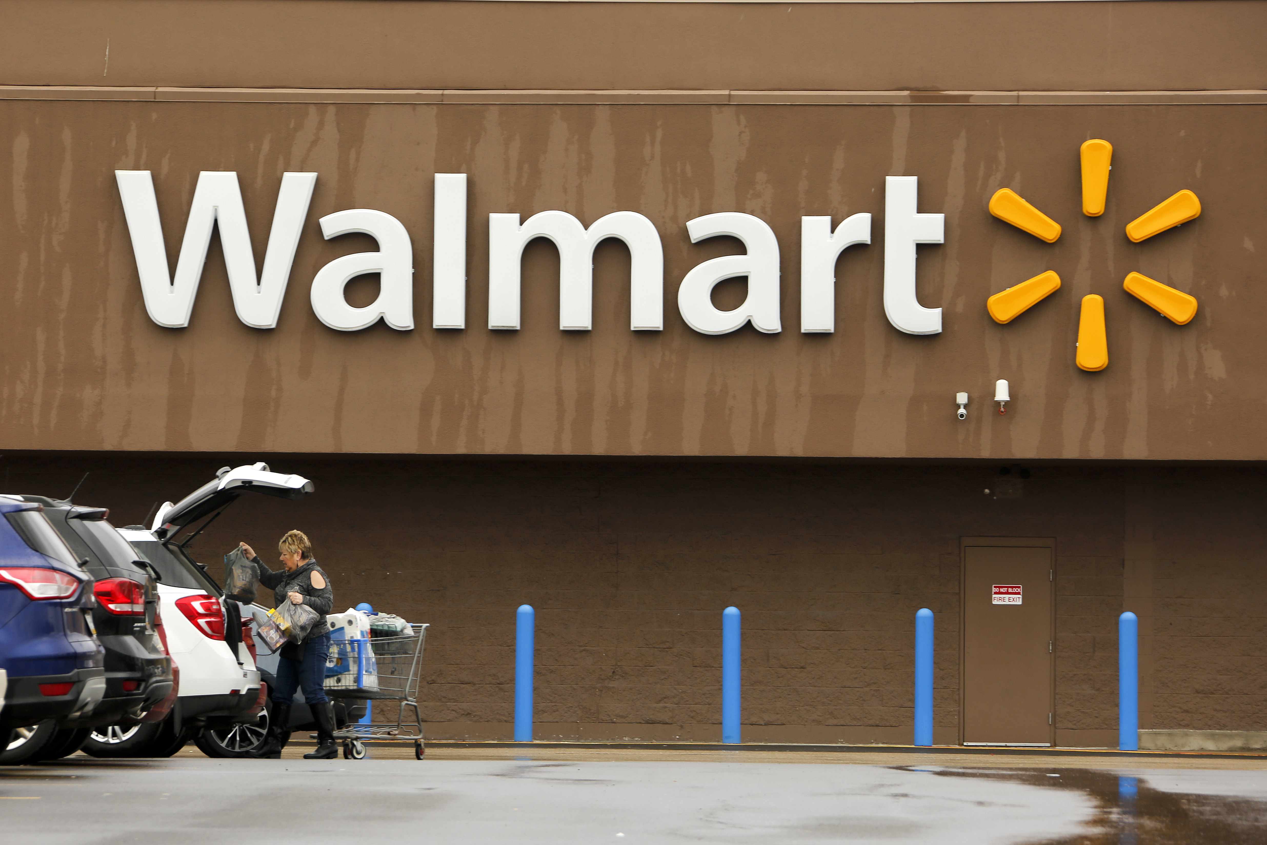 FILE - A shopper loads her car after shopping at a Walmart in Pittsburgh, Thursday, Feb. 22, 2018. Walmart announced Tuesday, April 30, 2024, is closing its health centers and virtual care service, as the retail giant has struggled to find success with the offerings. AP Photo/Gene J. Puskar, File)