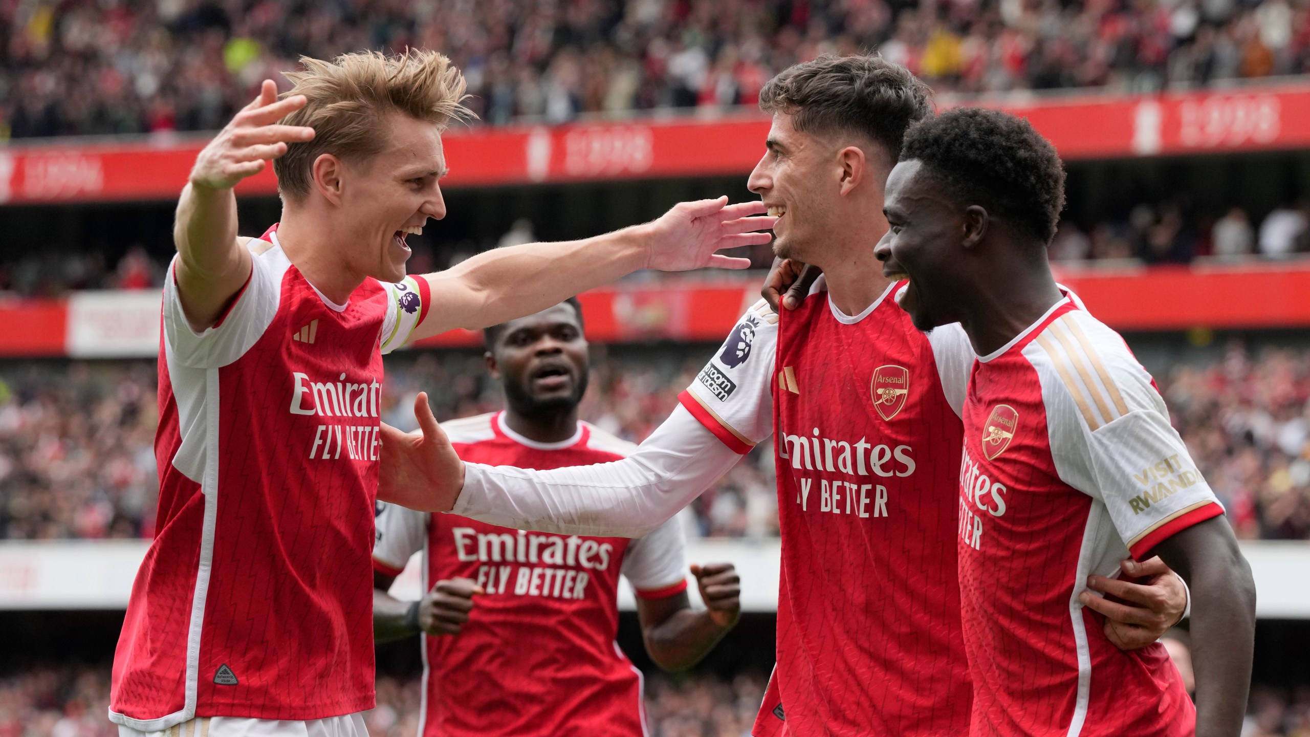 Arsenal's Bukayo Saka, right, celebrates with teammates after scoring his side's opening goal during the English Premier League soccer match between Arsenal and Bournemouth at Emirates Stadium in London, England, Saturday, May 4, 2024. (AP Photo/Frank Augstein)