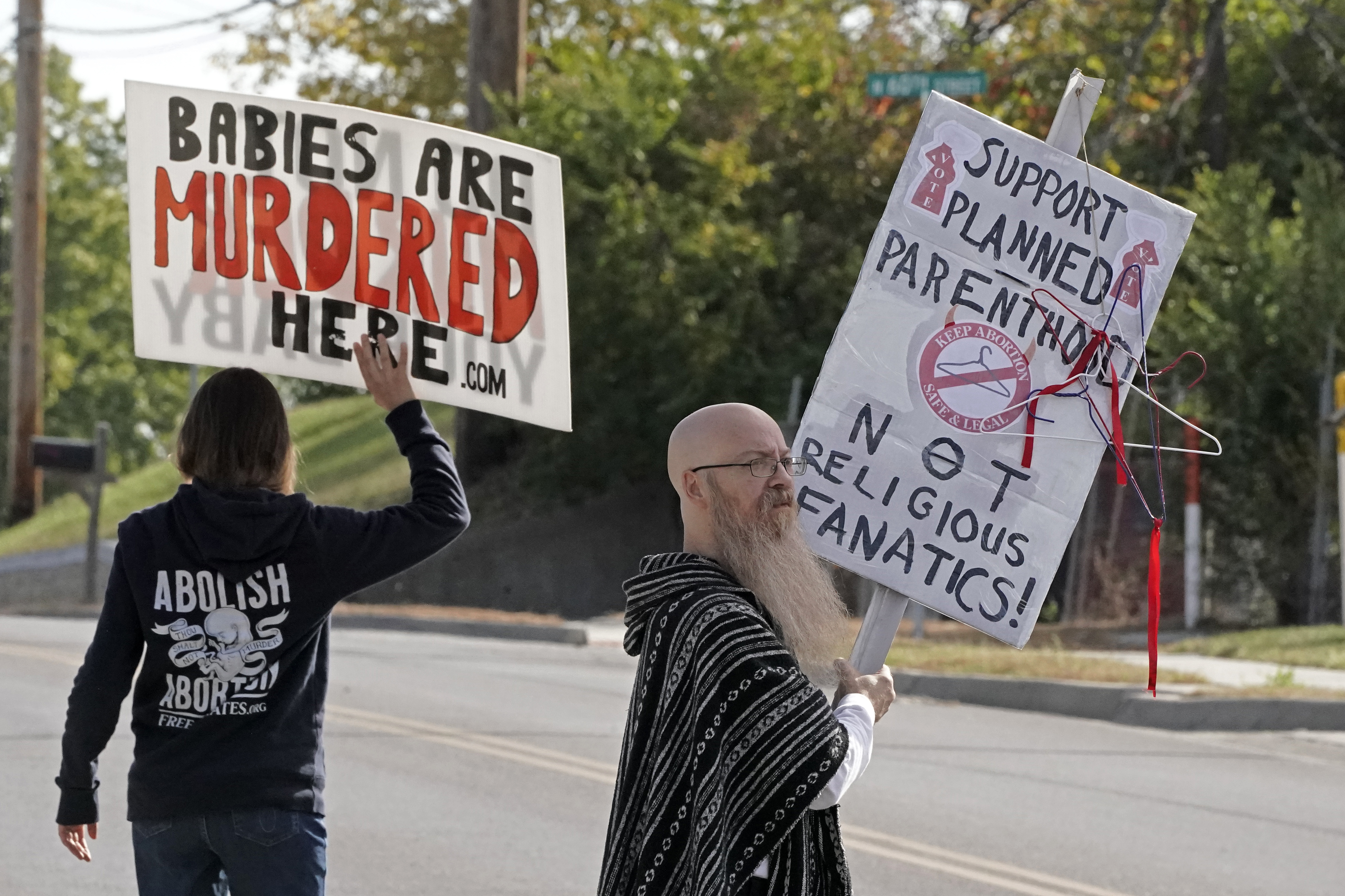 FILE - Demonstrators on both sides of the abortion issue stand outside a Planned Parenthood clinic, Oct. 15, 2022, in Kansas City, Kan. Comprehensive Health of Planned Parenthood Great Plains announced Tuesday, May 14, 2024, that Pittsburg, Kansas, will be home to a new facility providing abortion procedures and pills, as well as pregnancy services, contraception and testing and treatment for sexually transmitted diseases. (AP Photo/Charlie Riedel)