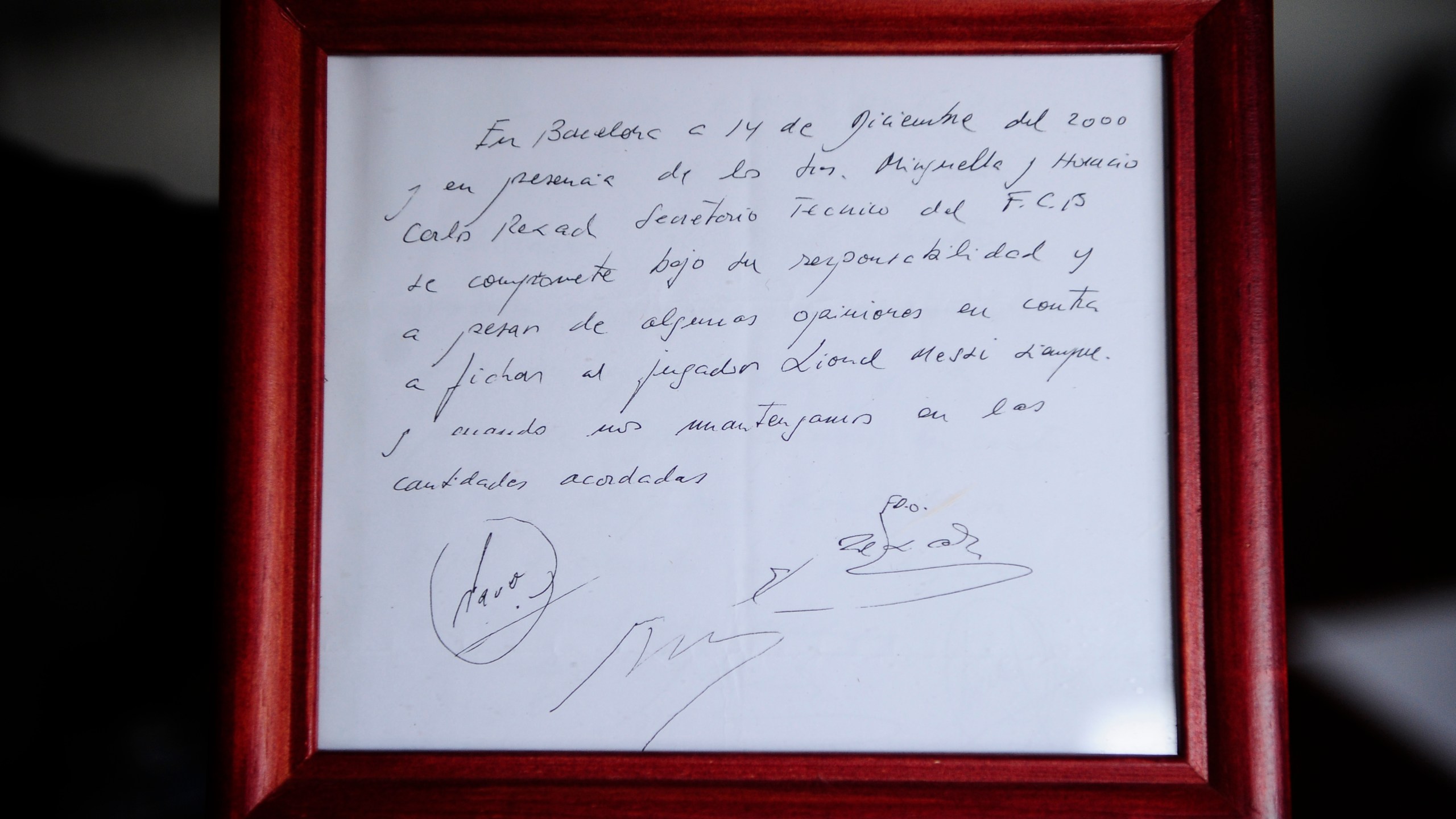 FILE - A framed copy of the napkin linking the 13-year-old Lionel Messi to FC Barcelona is seen in Barcelona, Spain on Jan. 5, 2012. British auction house Bonhams says the famous napkin that linked a young Lionel Messi to Barcelona has sold for $965,000. An agreement in principle to sign then 13-year-old Messi was written on the napkin almost 25 years ago at a Barcelona tennis club. (AP Photo/Manu Fernandez, File)