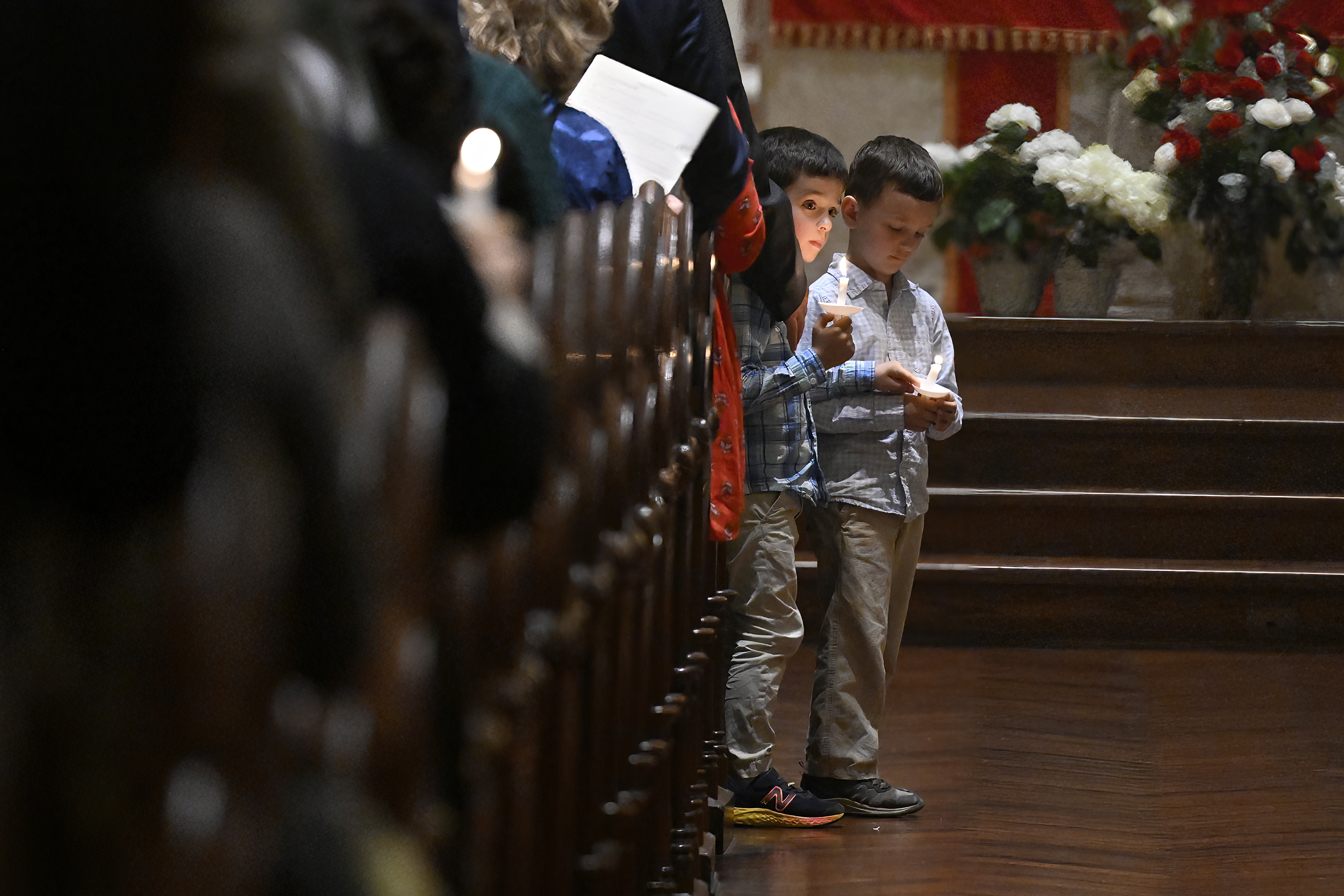 Two boys hold candles during a Pentecost Vigil at Blessed Michael McGivney Parish at St. Mary's Church, Saturday, May 18, 2024, in New Haven, Conn. The Eucharistic Procession from St. Mary's Church is one of four pilgrimage routes crossing the country and converging at the National Eucharistic Congress in Indianapolis, July 16. (AP Photo/Jessica Hill)