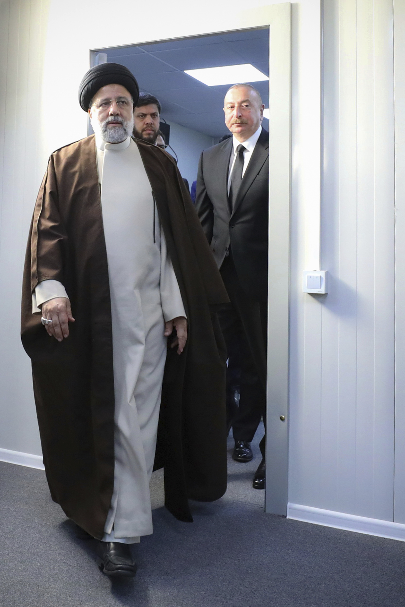 In this photo released by the Iranian Presidency Office, President Ebrahim Raisi, foreground, leaves the meeting room with his Azeri counterpart Ilham Aliyev, right, in the inauguration ceremony of dam of Qiz Qalasi, or Castel of Girl in Azeri, at the border of Iran and Azerbaijan, Sunday, May 19, 2024. A helicopter carrying Iranian President Ebrahim Raisi suffered a "hard landing" on Sunday, Iranian state media reported, without immediately elaborating. (Iranian Presidency Office via AP)