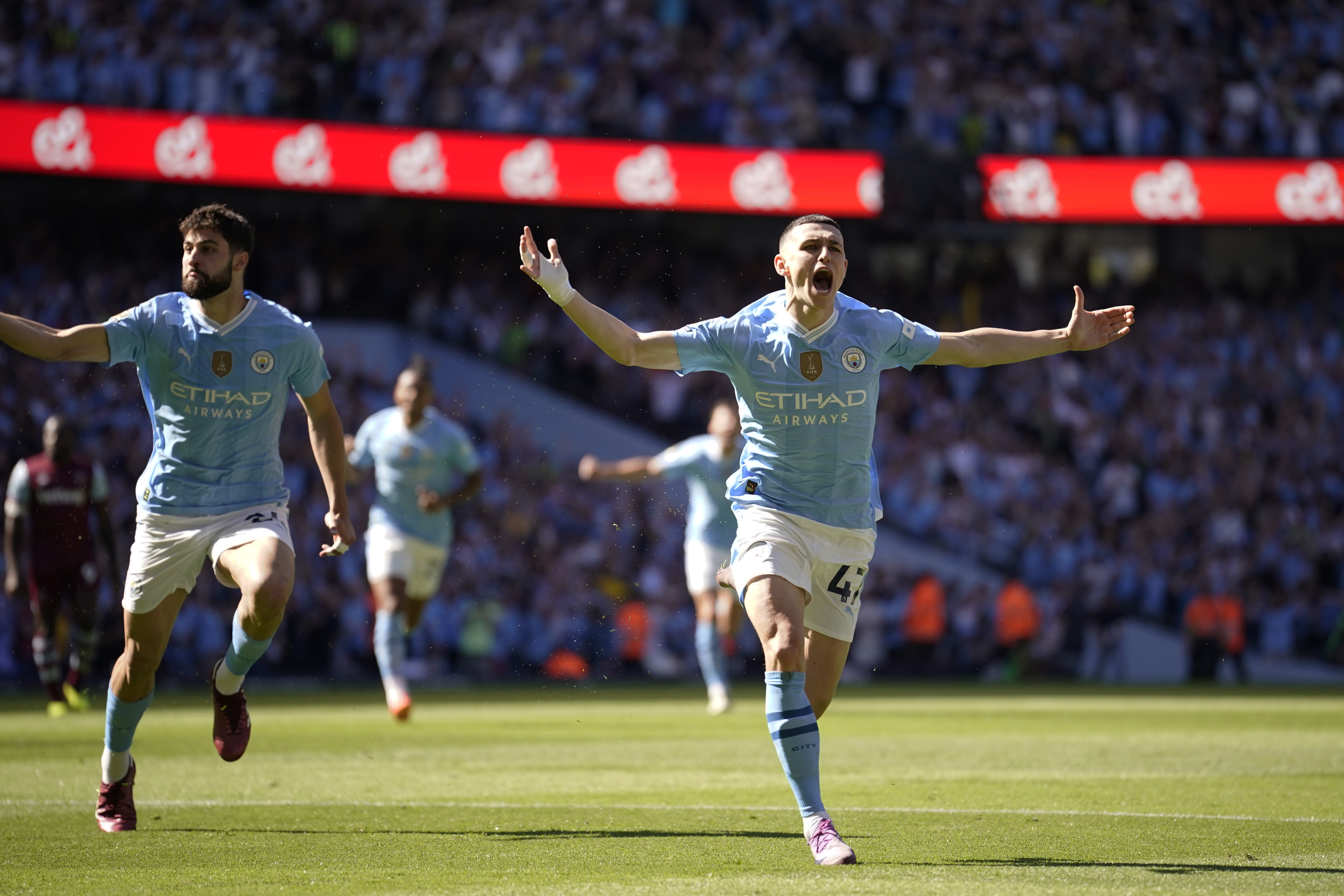 Manchester City's Phil Foden, right, celebrates after scoring his side's opening goal during the English Premier League soccer match between Manchester City and West Ham United at the Etihad Stadium in Manchester, England, Sunday, May 19, 2024. (AP Photo/Dave Thompson)