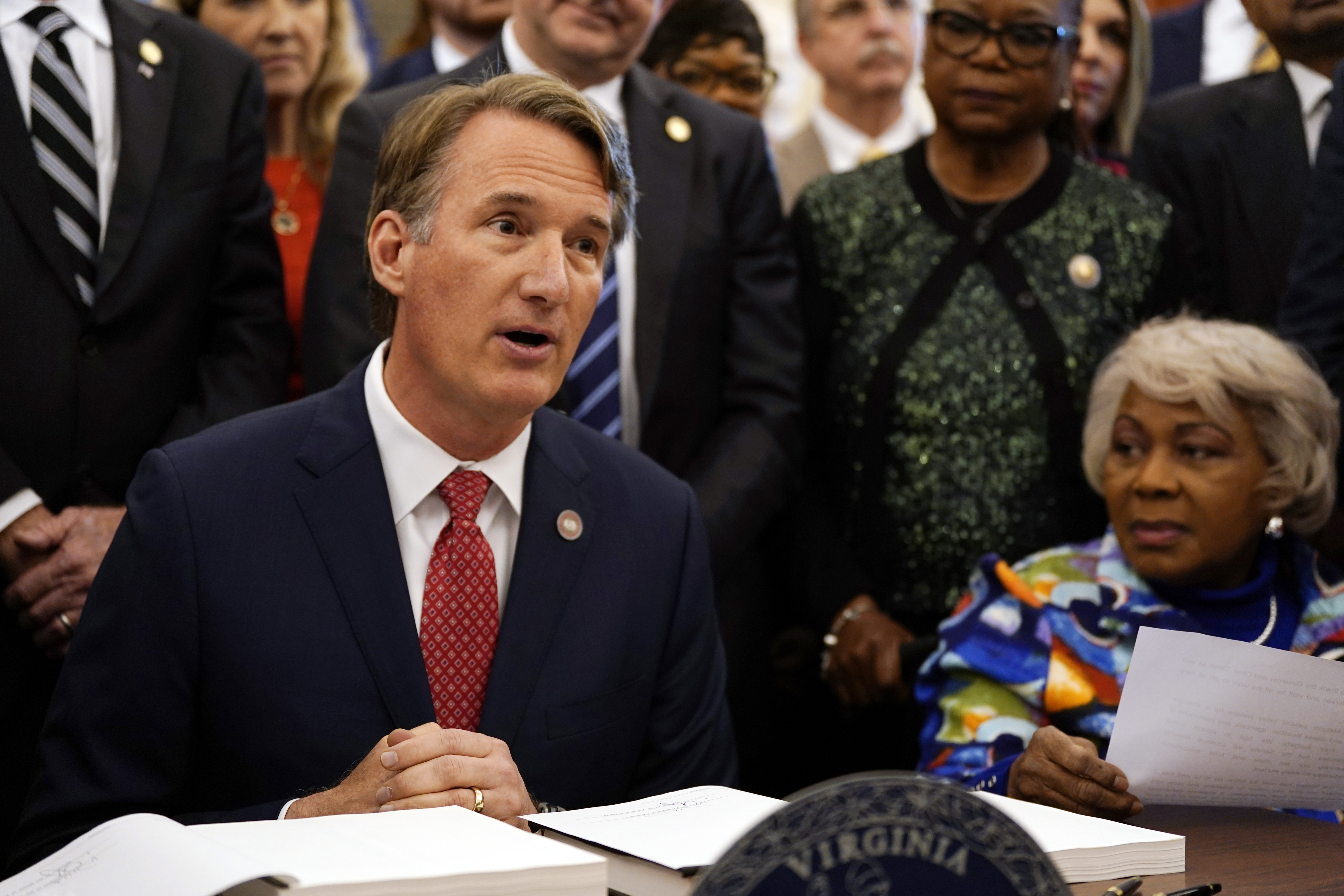 FILE -Virginia Gov. Glenn Youngkin, left, speaks before signing the budget bill that was passed by both chambers at the Capitol May 13, 2024, in Richmond, Va. Senate Finance Committee Chairman, State Sen. Louise Lucas, D-Portsmouth, right, listens. Republican lawmakers in states across the U.S. have been rejecting Democrats' efforts to protect or expand access to birth control, an issue Democrats are promoting as a major issue in this year's elections along with abortion and other reproductive rights concerns. (AP Photo/Steve Helber, File)