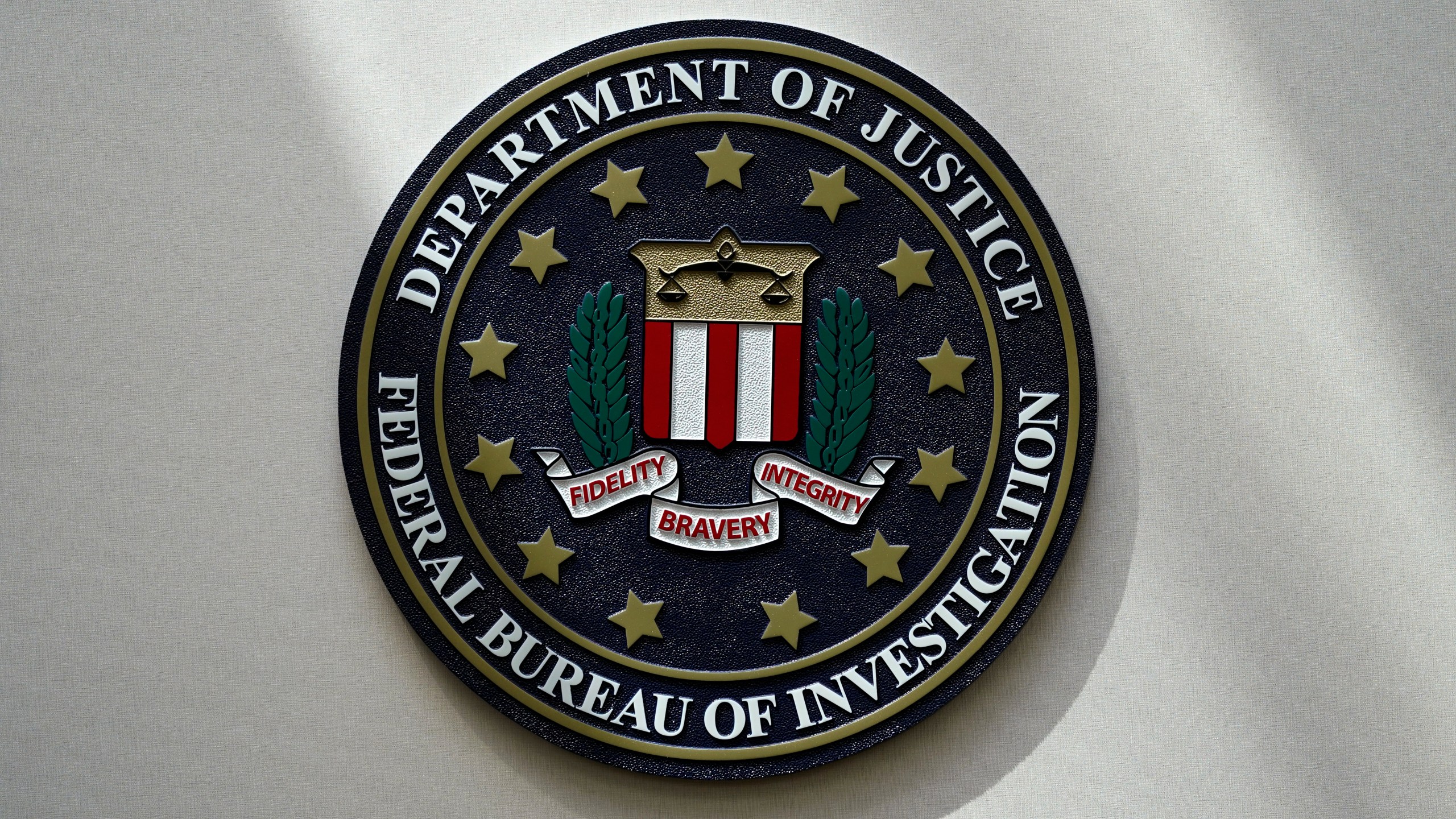 FILE - An FBI seal is seen on a wall on Aug. 10, 2022, in Omaha, Neb. The Biden administration is taking credit for a sharp drop in violent crime nationwide earlier this year but one expert cautions that the declines in FBI data are preliminary and likely overstated. (AP Photo/Charlie Neibergall, File)