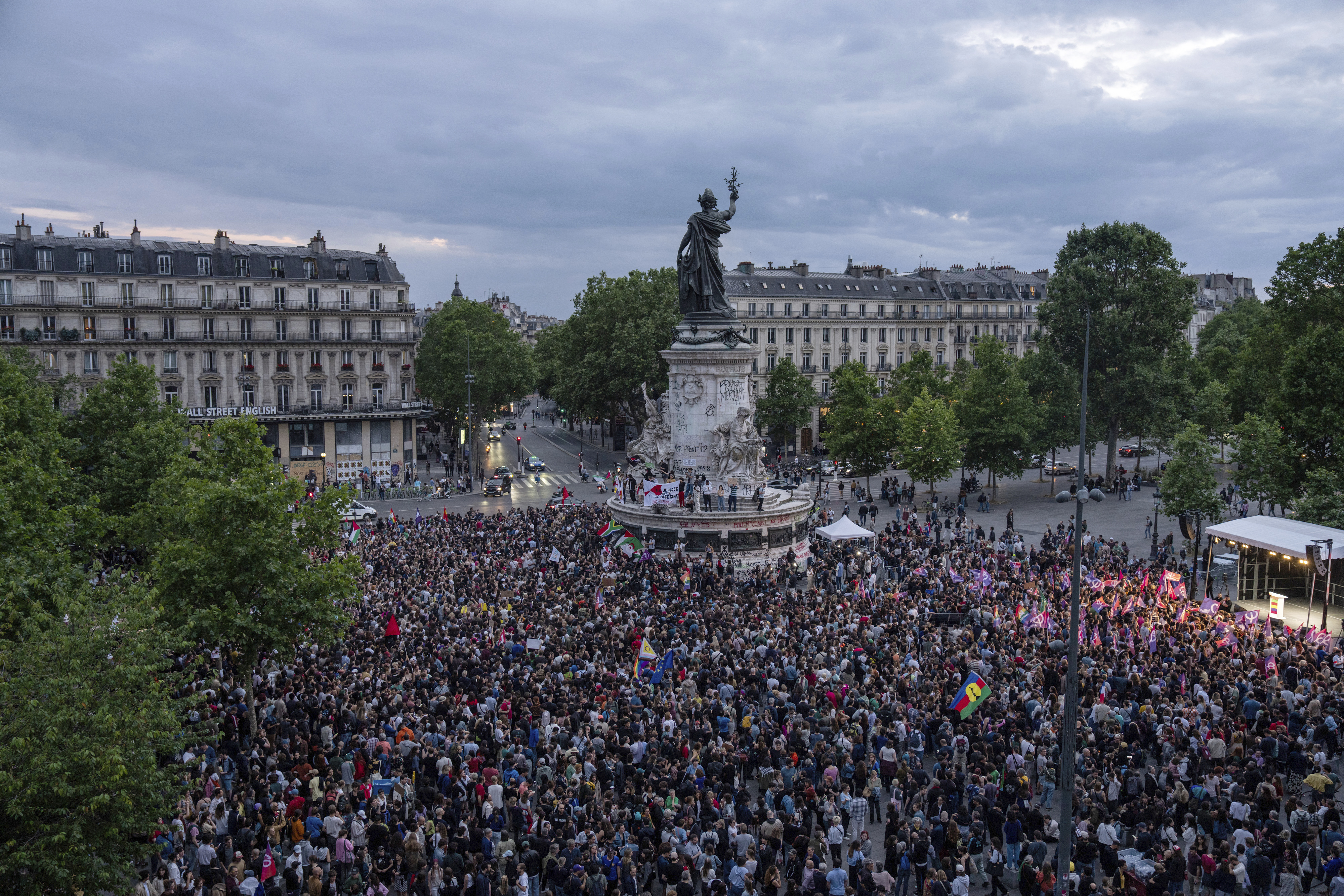 People gather at Republique square to protest the far-right National Rally, which came out strongly ahead in first-round legislative elections, Sunday, June 30, 2024 in Paris. France's high-stakes legislative elections propelled the far-right National Rally to a strong but not decisive lead in the first-round vote Sunday, polling agencies projected, dealing another slap to centrist President Emmanuel Macron. (AP Photo/Louise Delmotte)