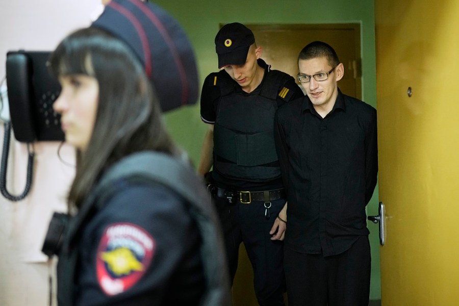 Robert Woodland, right, a Russia-born U.S. citizen, is escorted to the courtroom for a hearing, Thursday, July 4, 2024, in Moscow, Russia. Woodland was convicted of drug-related charges and sentenced to 12 and a 1/2 years in prison on Thursday. (AP Photo/Alexander Zemlianichenko)