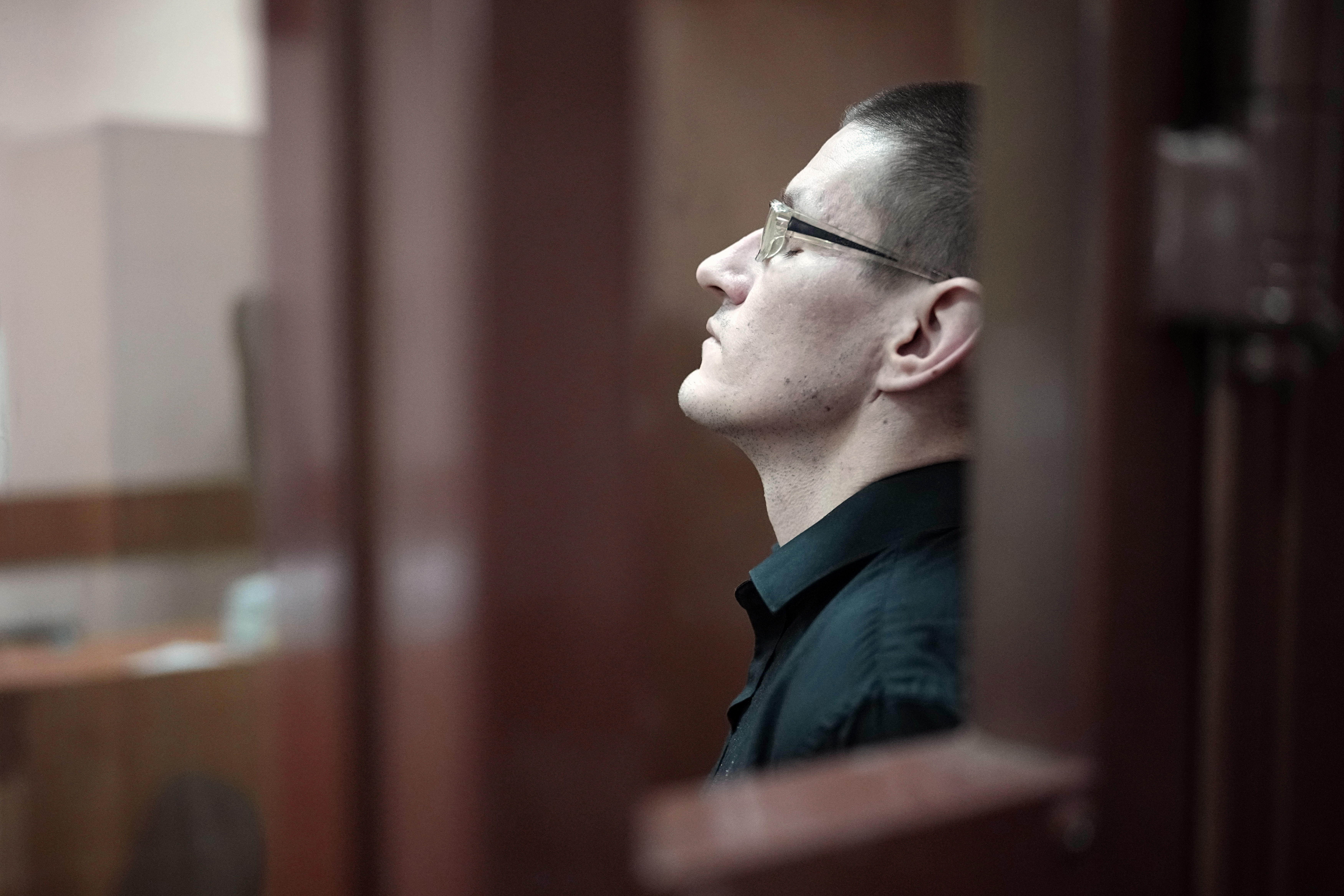 Robert Woodland, a Russia-born U.S. citizen, stands in a glass cage during a court hearing, Thursday, July 4, 2024, in Moscow, Russia. Woodland was convicted of drug-related charges and sentenced to 12 and a 1/2 years in prison on Thursday. (AP Photo/Alexander Zemlianichenko)