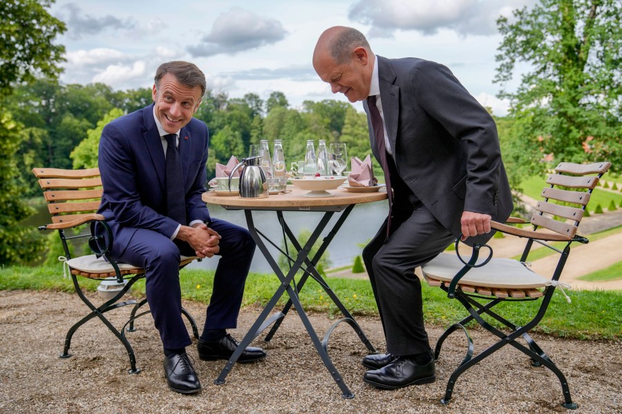 FILE - German Chancellor Olaf Scholz, right, and French President Emmanuel Macron sit at a table in the garden of the German government guest house in Meseberg, north of Berlin, Germany, on May 28, 2024. (AP Photo/Ebrahim Noroozi, Pool)